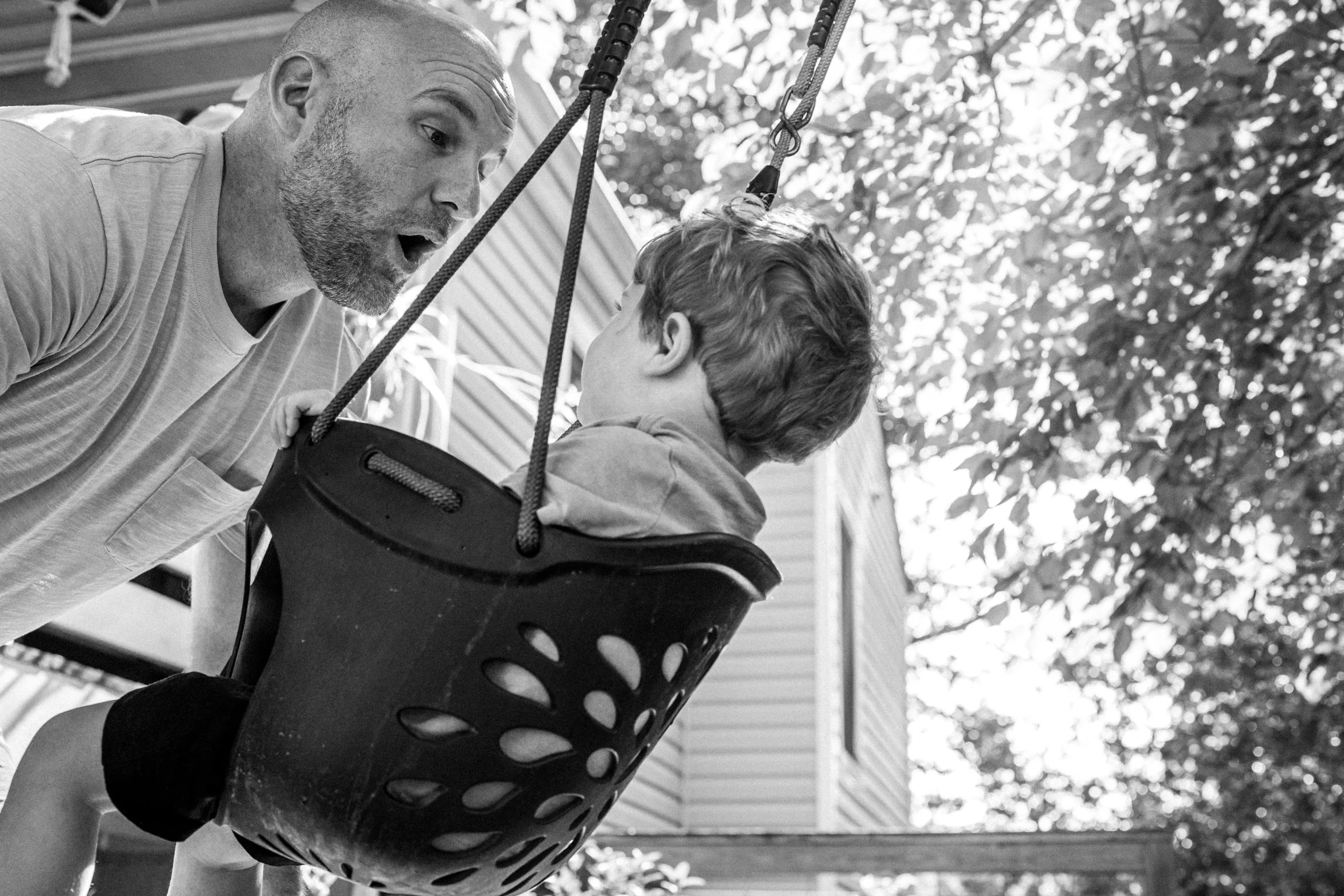 Dad pushing his son on a swing