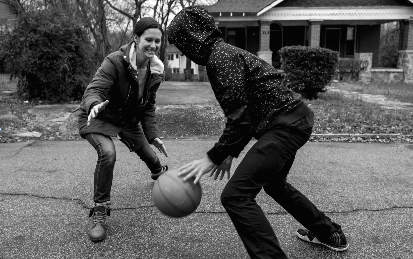 Mom laughing and playing basketball with her teenage son on an Atlanta street