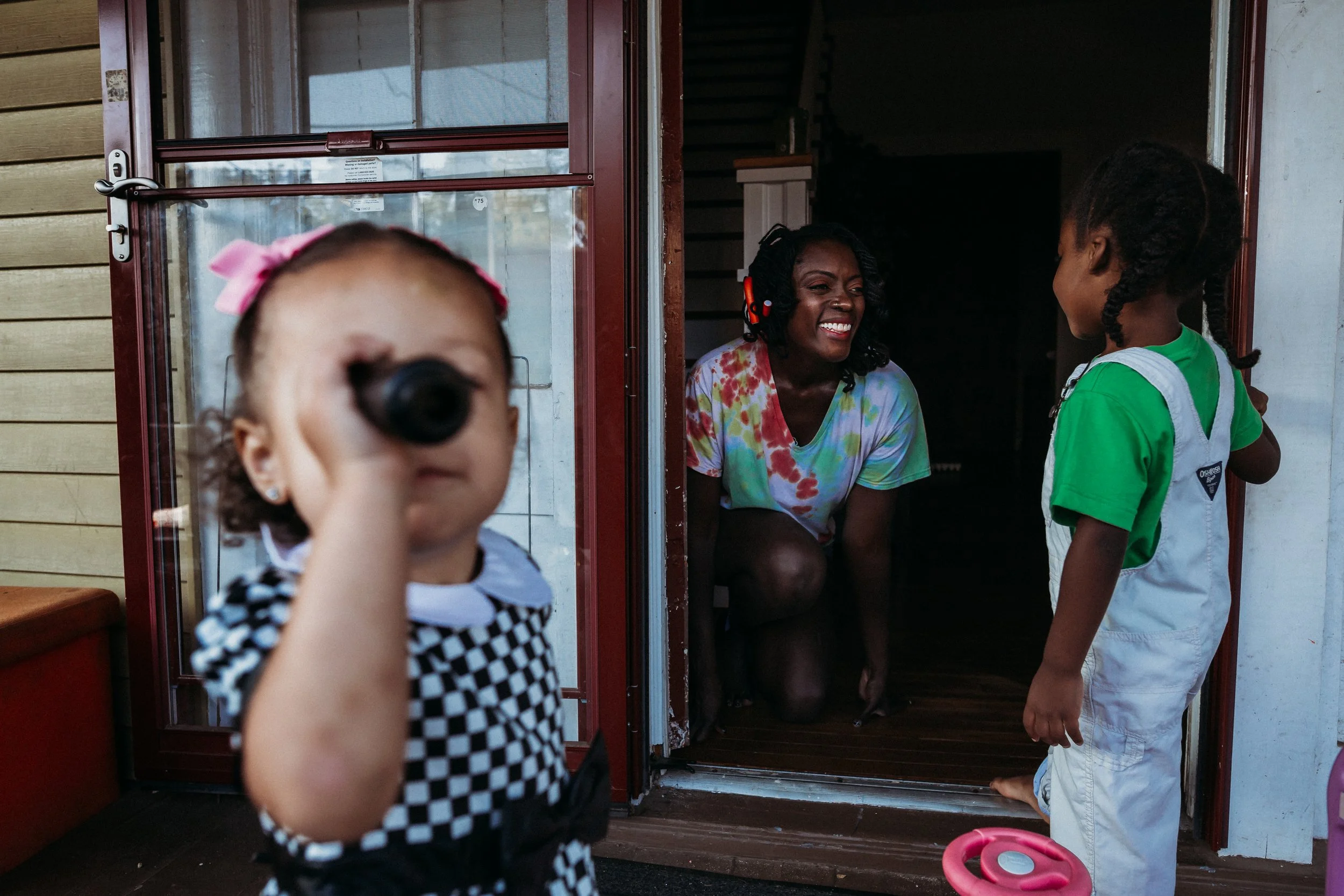 Mom bending down and smiling at her son on their front porch