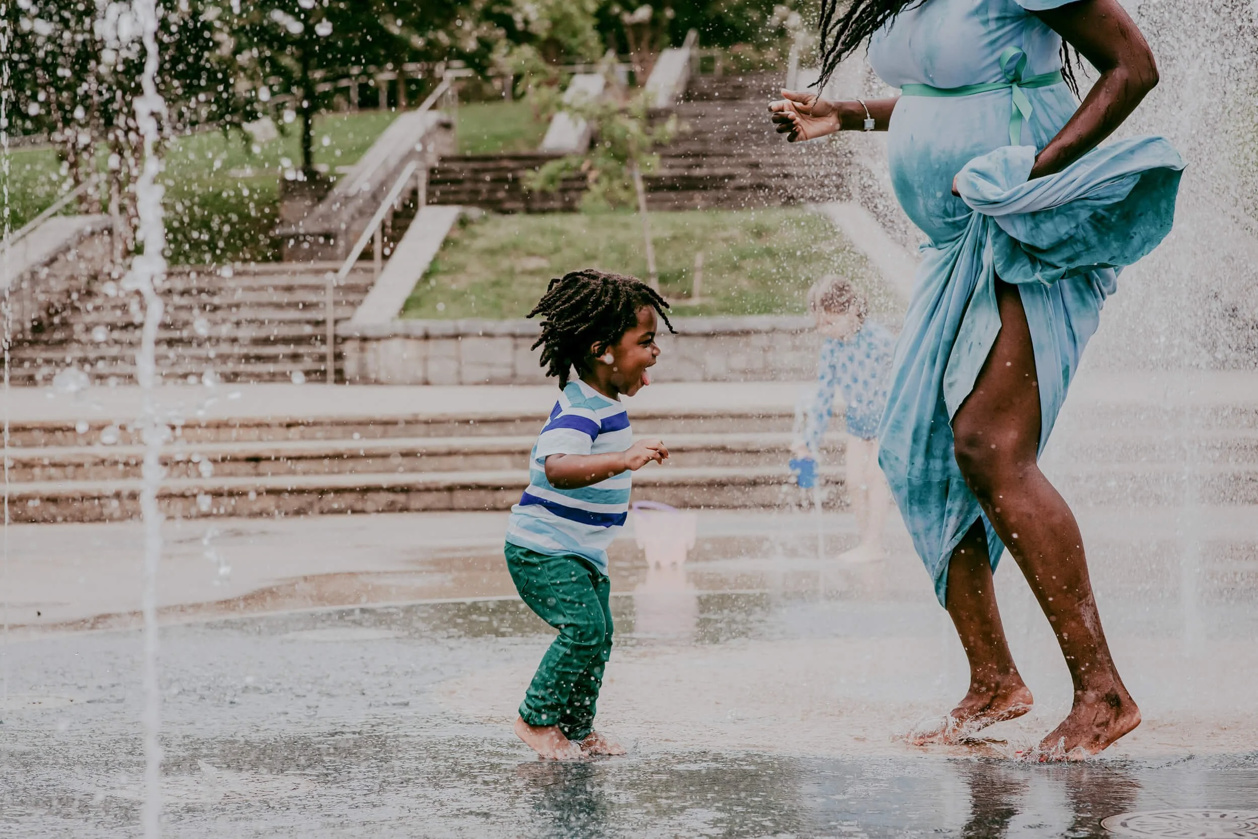 pregnant woman in an Atlanta splash pad with her toddler son