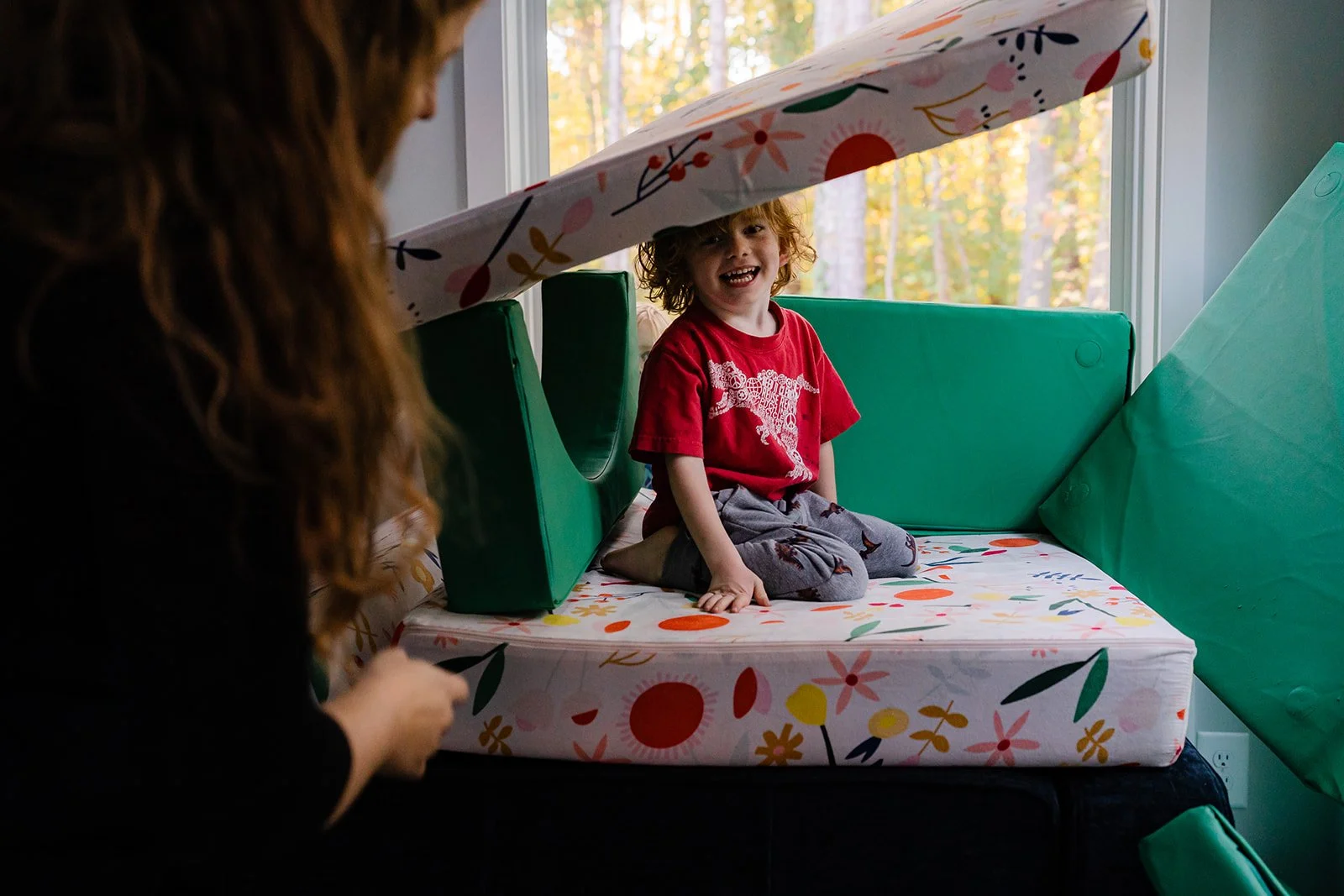 A boy playing in pillows on the couch in his Atlanta living room