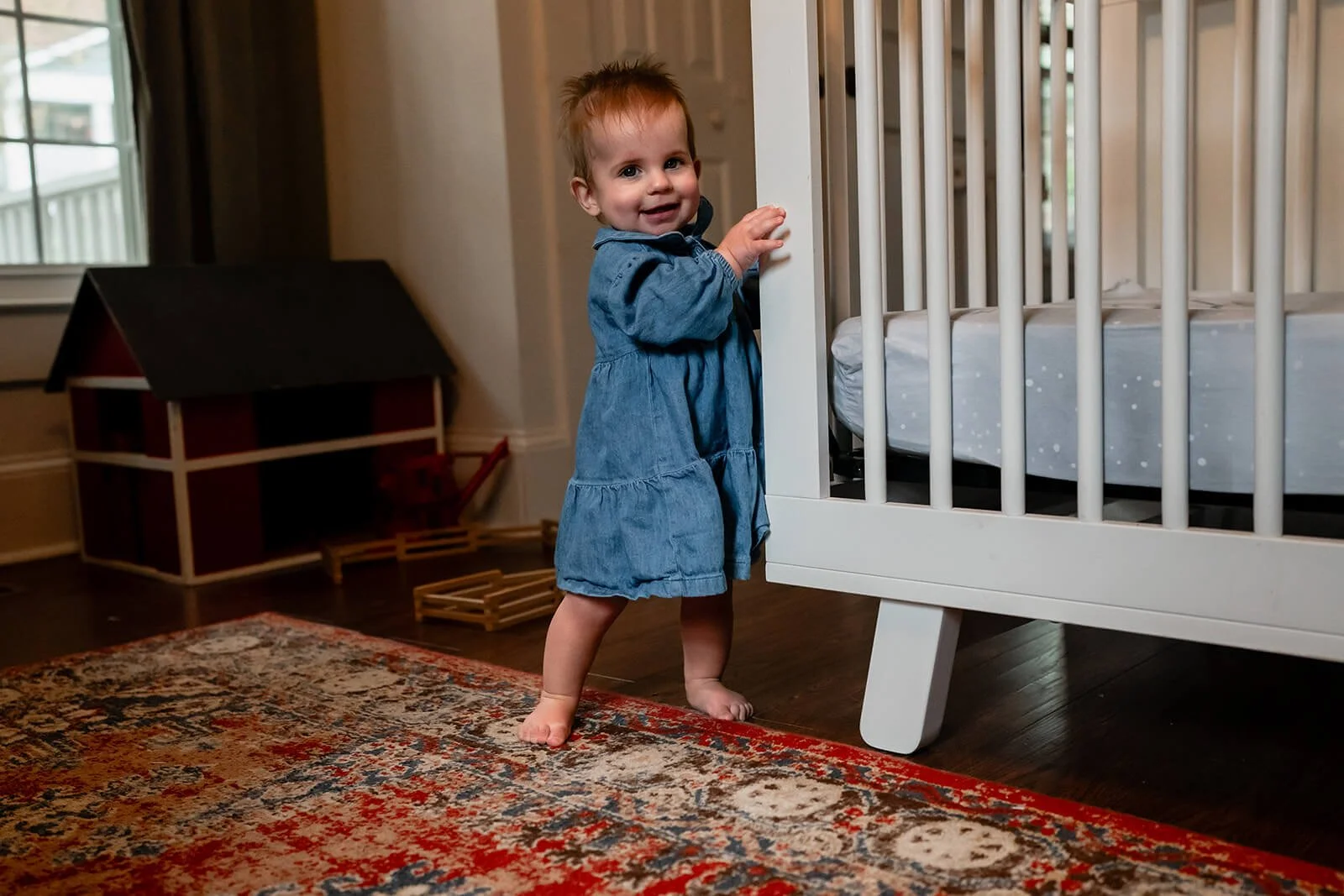 baby girl at home in her nursery just starting to walk