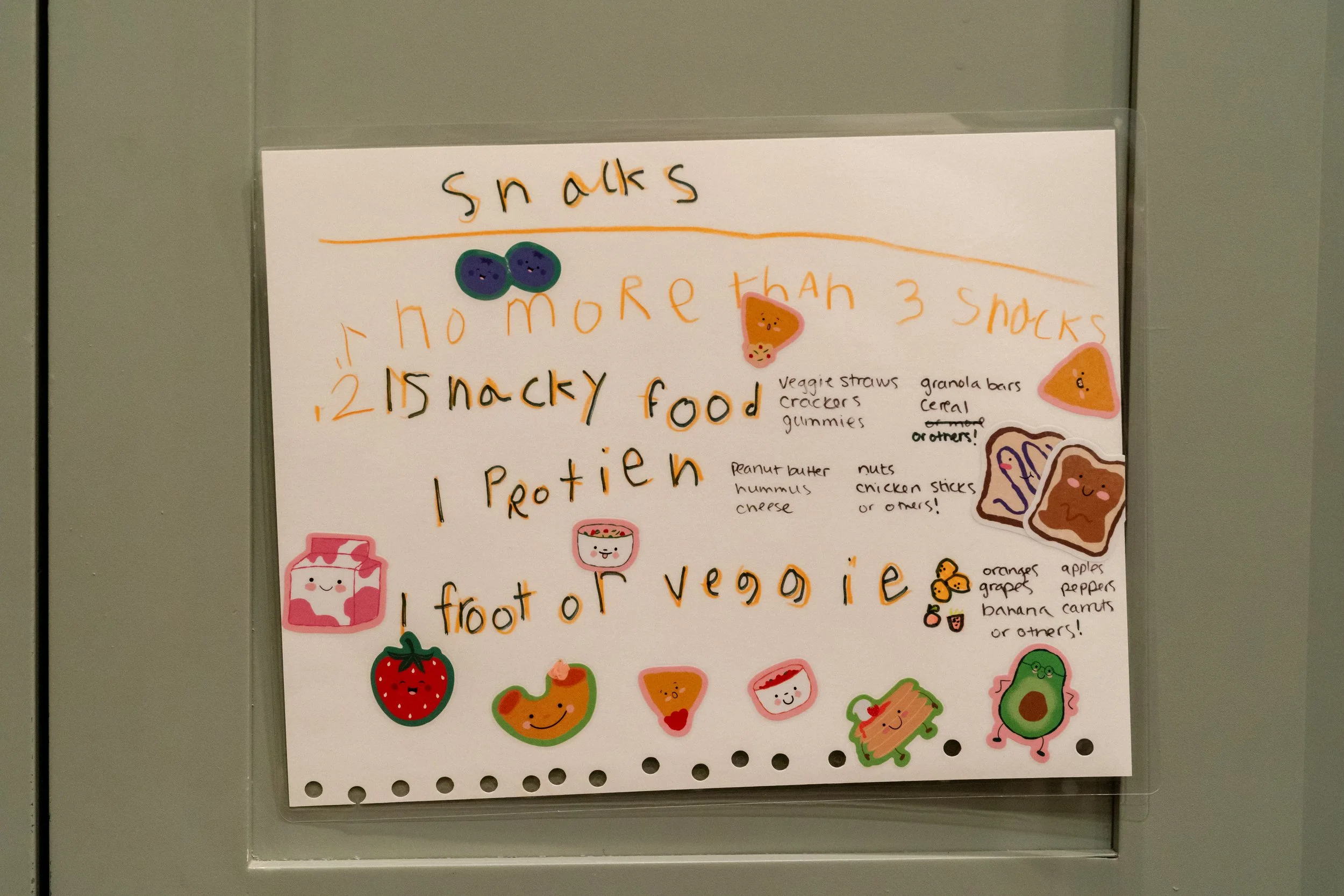 A family's snack schedule written in a child's handwriting, taped to the kitchen cabinet