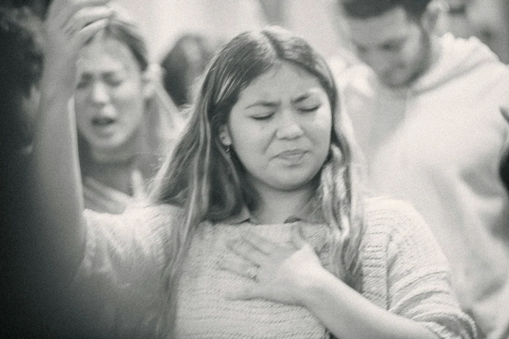 A woman with her hand over her heart, praying