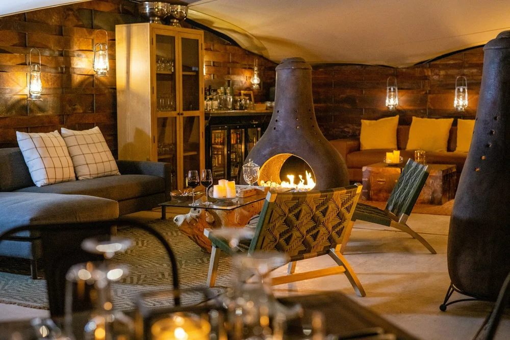 A cozy lounge with a fire pit and warm lights