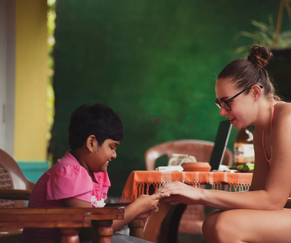 A young person and a mentor sitting together at a table