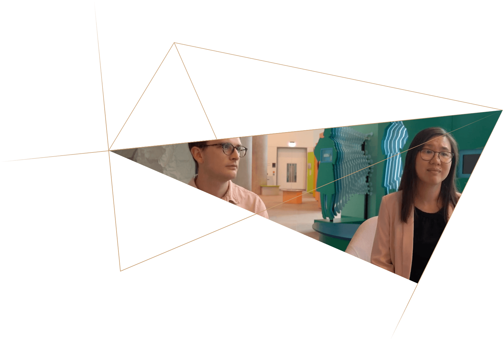 Two women sitting in a modern indoor space with colorful wall art and a door in the background.