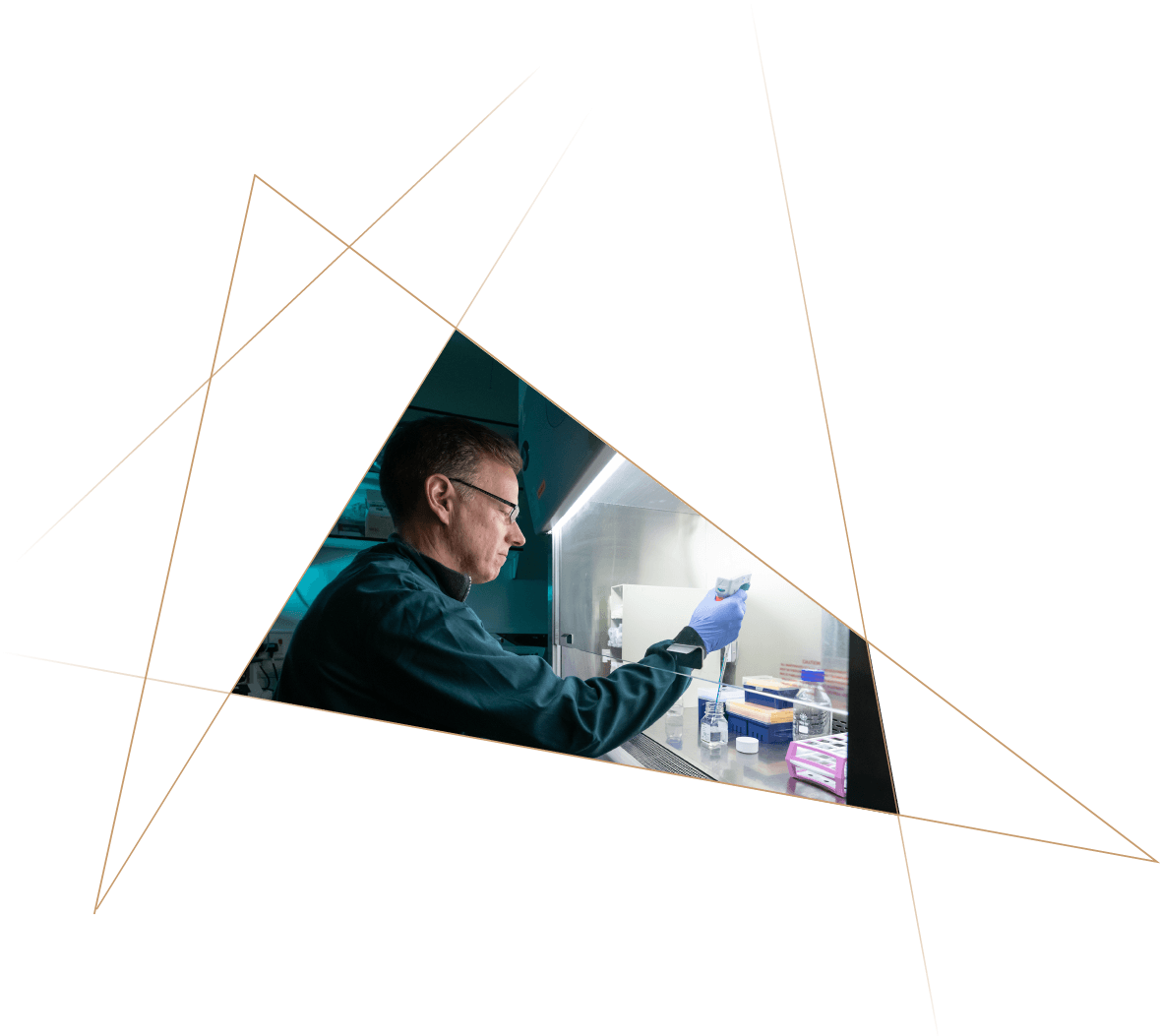 A scientist wearing glasses and gloves working with laboratory equipment in a sterile environment, using a pipette.