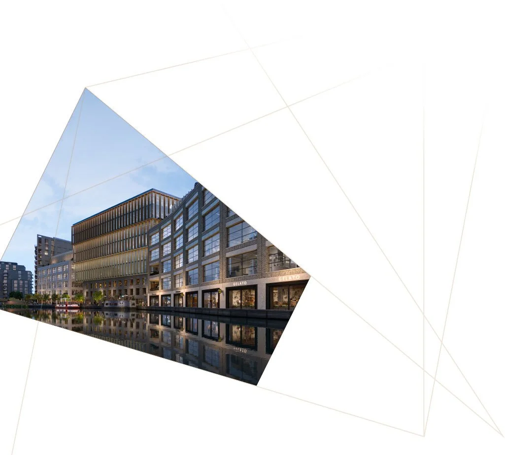 Modern multi-story commercial and residential buildings along a canal with reflections, under a blue sky.