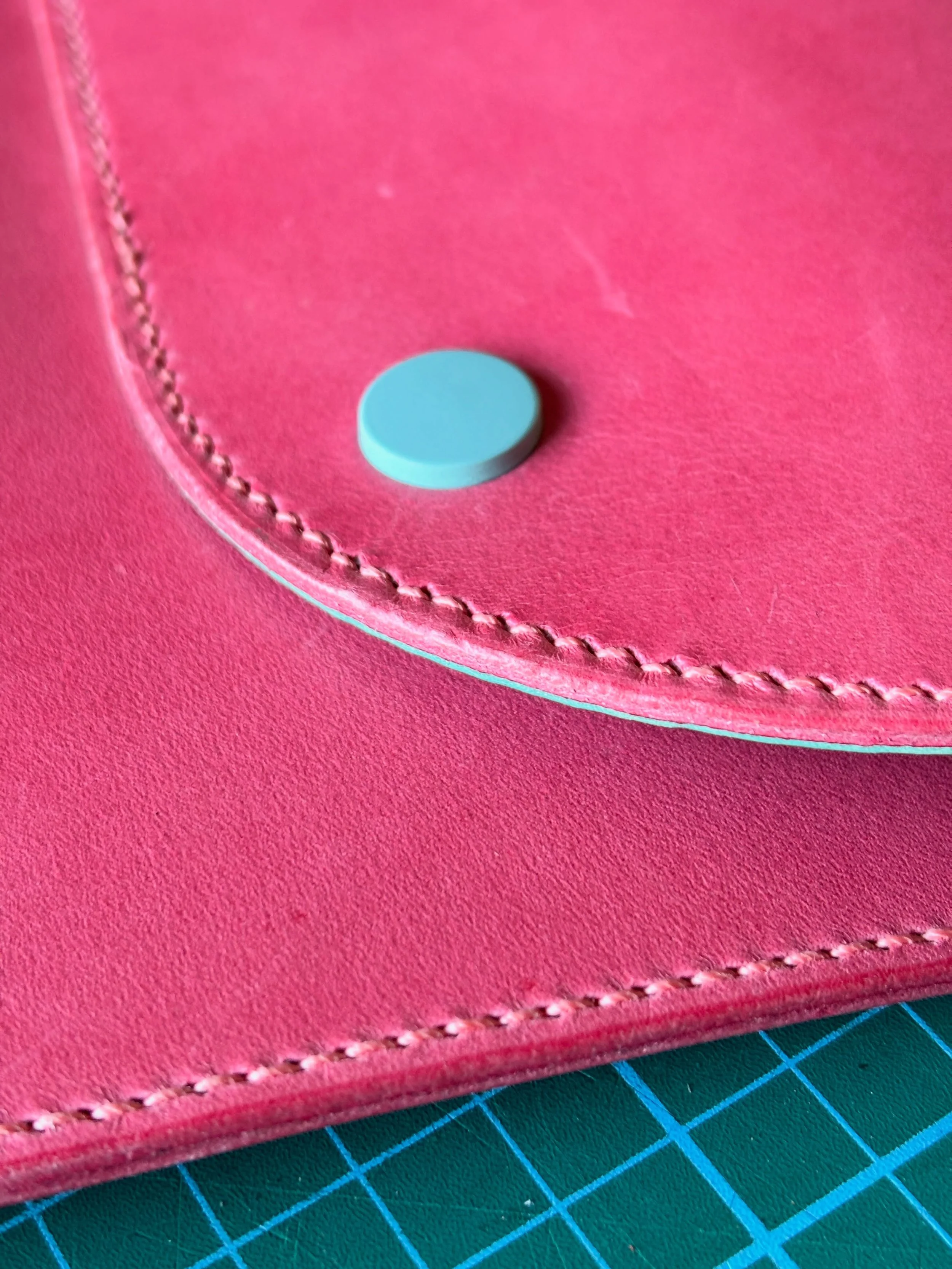 A commission for a lovely client&rsquo;s friend for her 50th birthday - a bespoke pink vegetable tanned leather laptop pouch with turquoise lining and matching poppers. Saddle stitched with linen thread and finished with her name engraved. Swipe to s