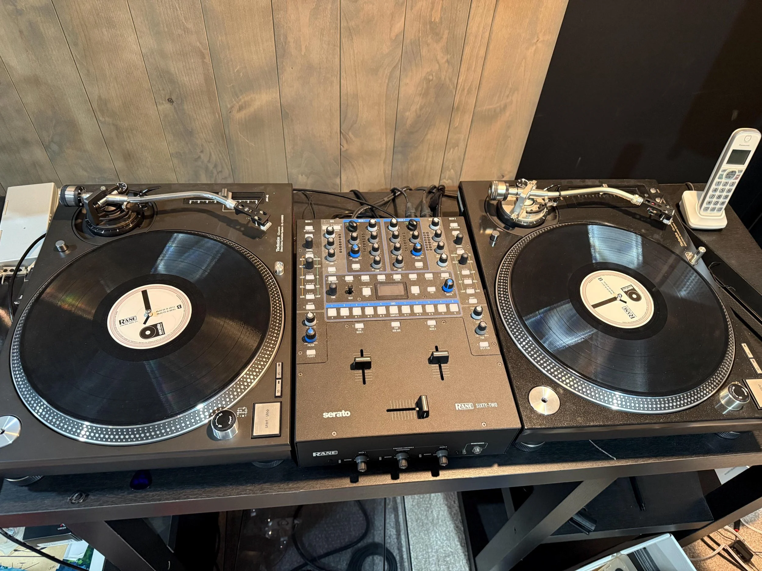 Detail image of the original DJ setup showing exposed cables, awkward equipment layout, and furniture not suited for long-term use or vibration control.
