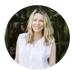 Portrait of a young woman with blonde hair wearing a white top outdoors