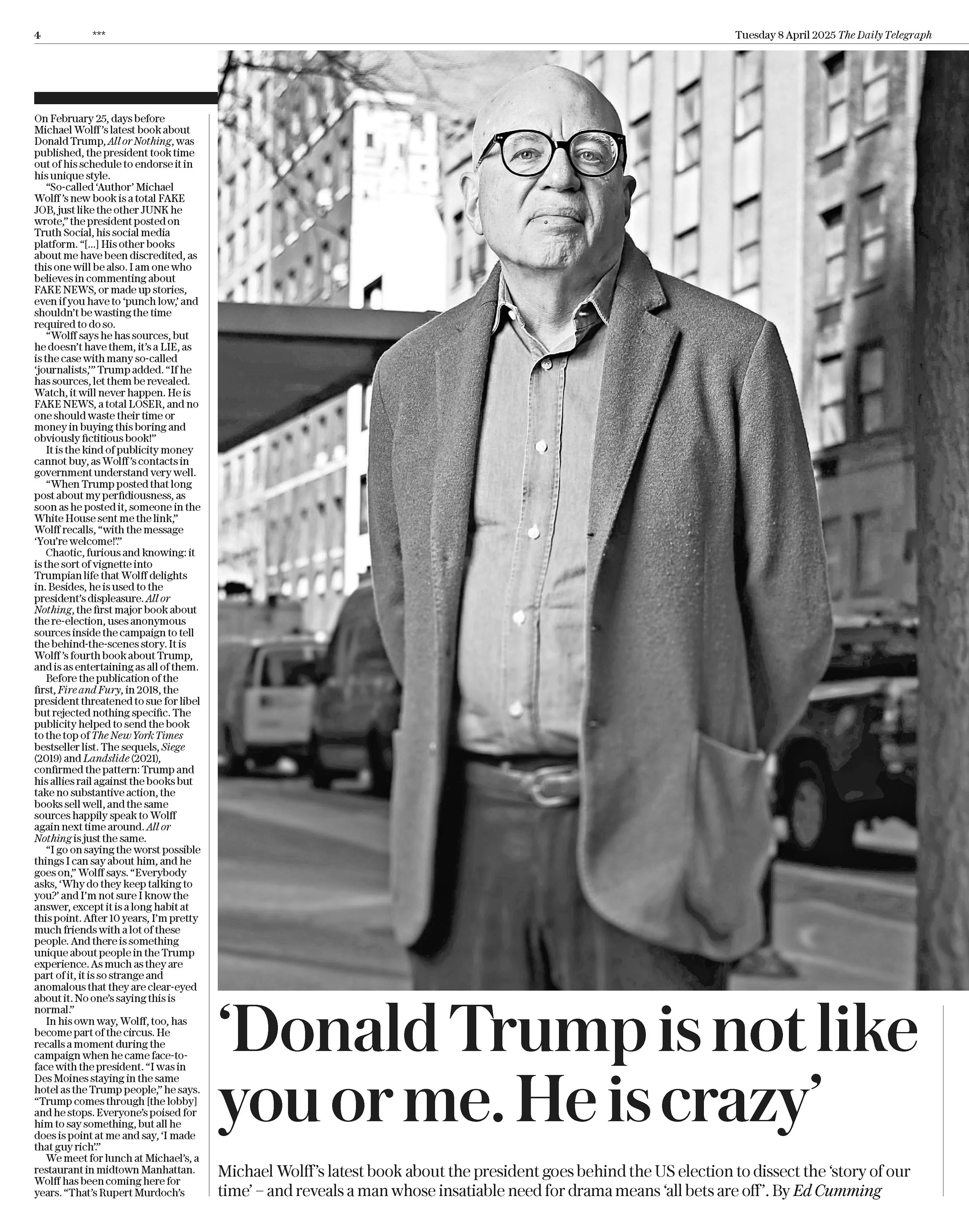 A black-and-white photograph of Michael Wolff, a bald man wearing glasses, a collared shirt, and a blazer. He is outdoors, standing in front of a brick building with a metal staircase and trees in the background.