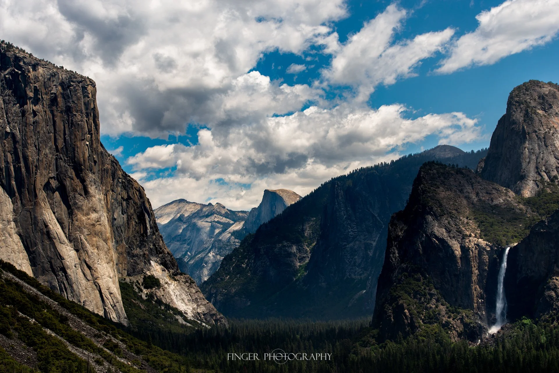 Daytime photo from Inspiration Point featuring El Capitan, Half Dome and Bridalveil Falls