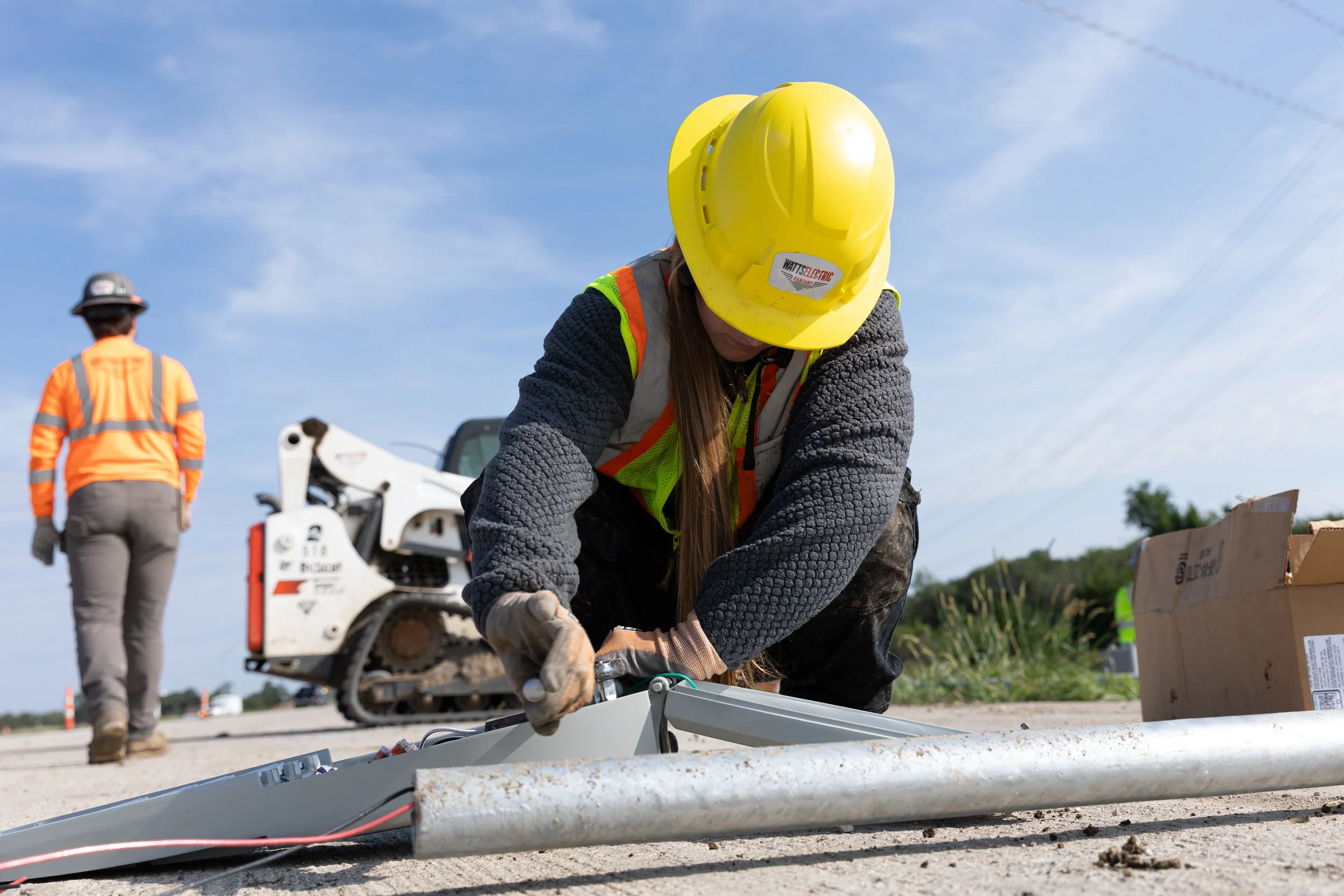 Construction woman installing a light on a pole for street lamps, shot by commercial photographer Corey Rourke 