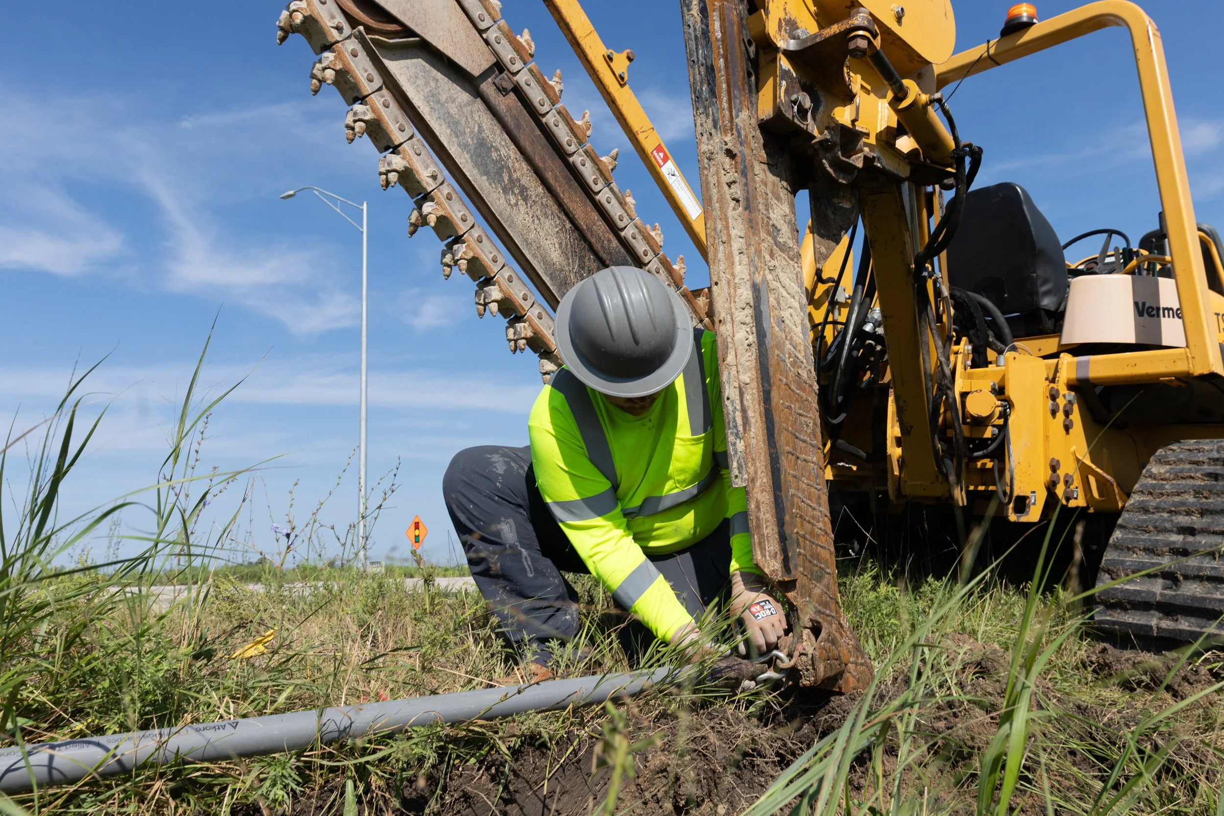 Construction worker fitting equipment on vehicle shot by commercial photographer Corey Rourke