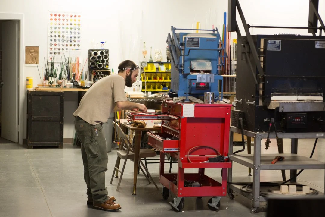 glass blower grabbing equipment from tool box, shot by commercial photographer Corey Rourke

