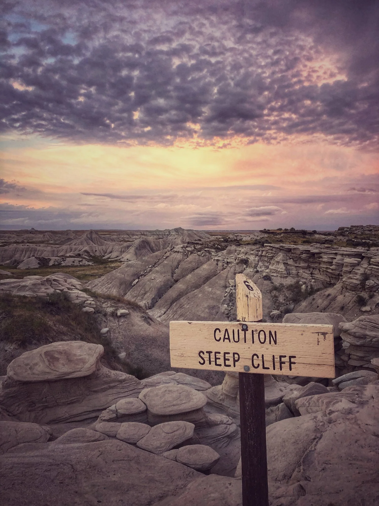 vibrant image of toadstool national park with sign in the foreground and gradient sky in the background
