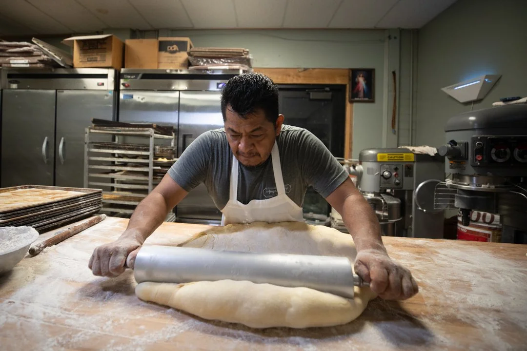baker using a rolling pin to roll out dough, shot by commercial photographer Corey Rourke
