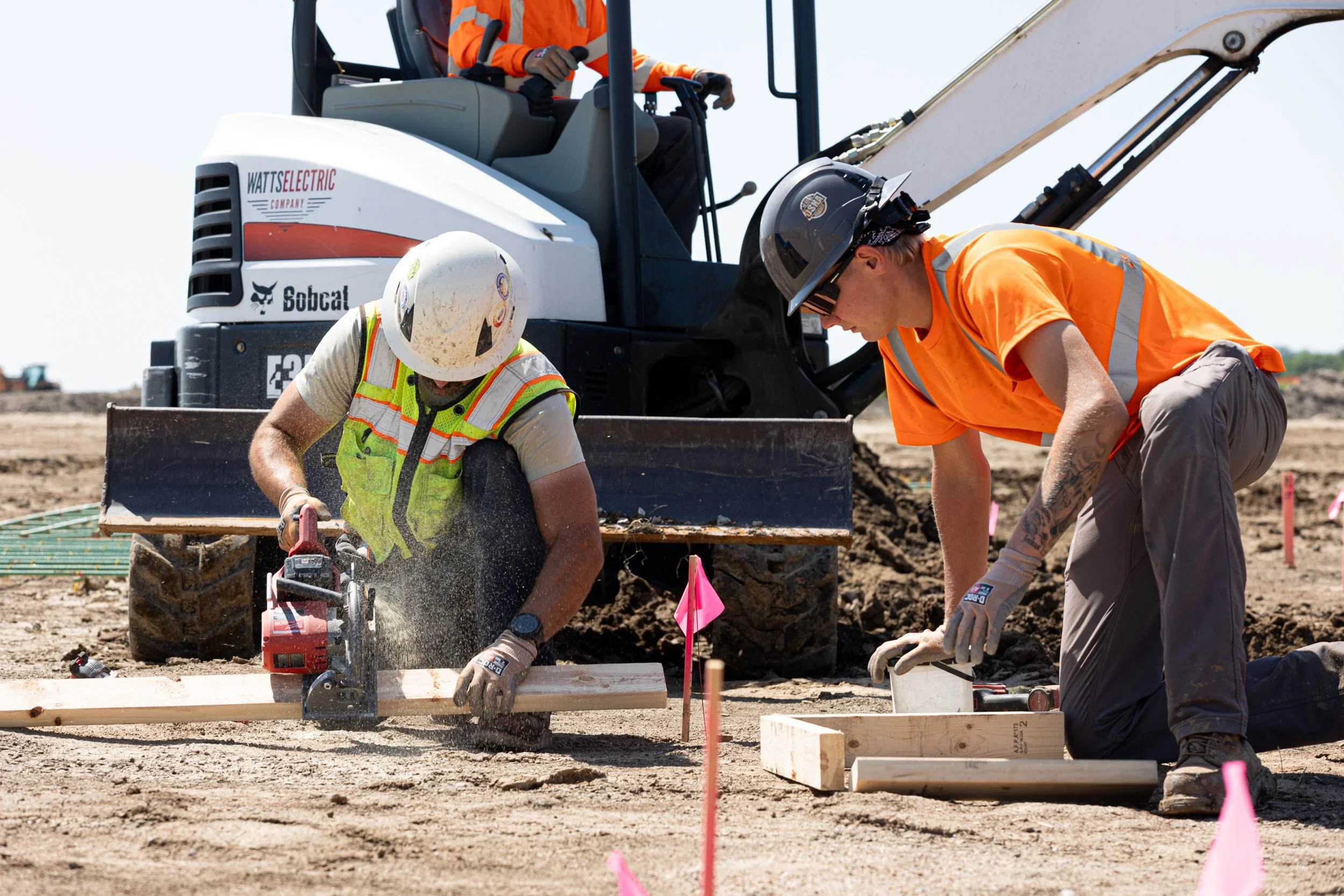 Construction worker using a saw to cut wood on site, shot by commercial photographer Corey Rourke