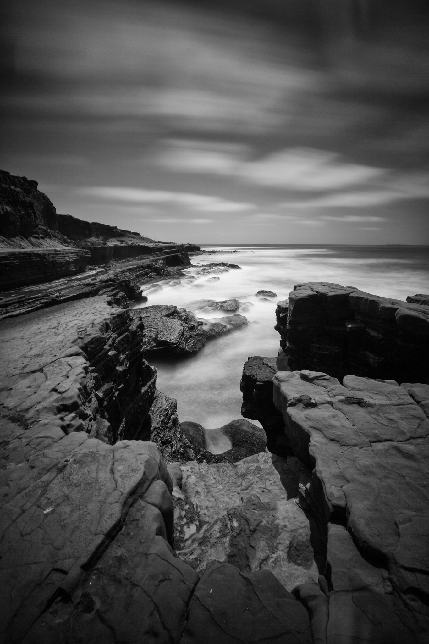 black and white image of cliff looking down at the water