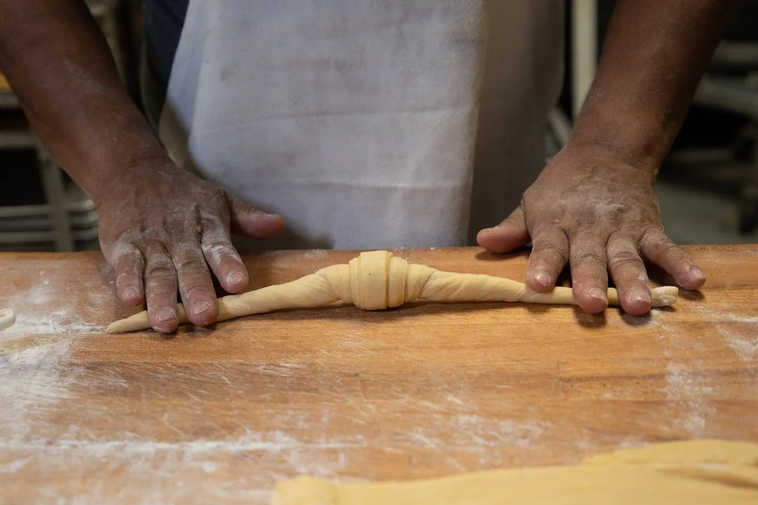 close up of bakers hands rolling crosiant, shot by commercial photographer Corey Rourke
 