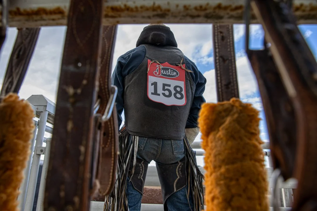 image of back of bull rider with belts and straps in the foreground, shot by commercial photographer Corey Rourke

