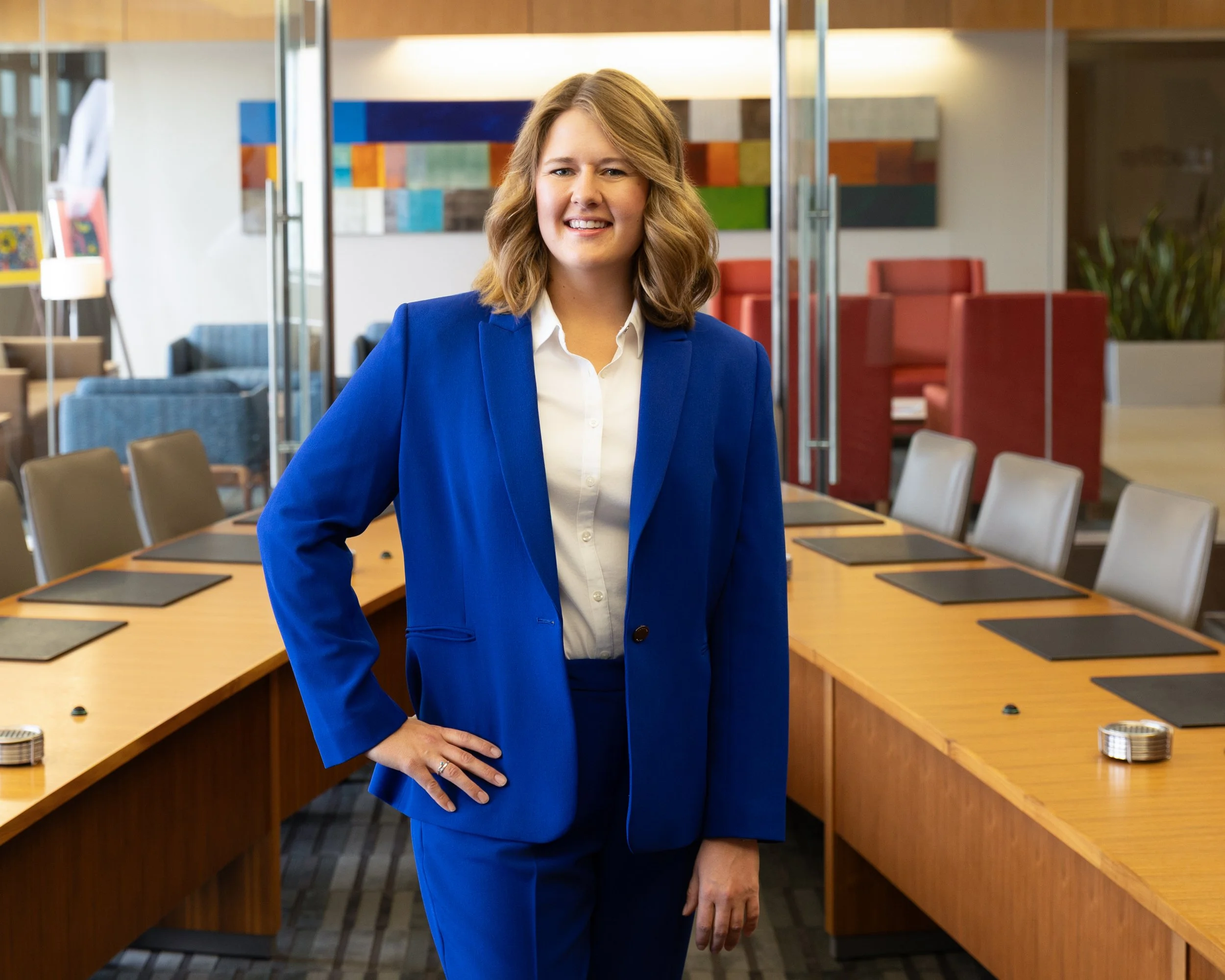 Corporate headshot of a woman  in a blue suit in a conference room