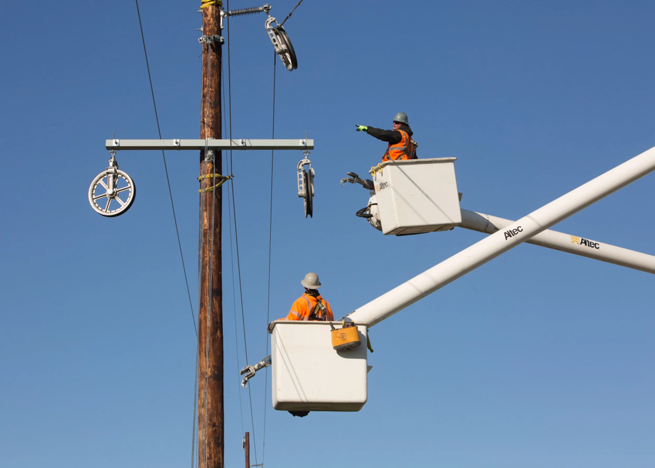 commercial electrician in tubs inspecting wires and poles, shot by commercial photographer Corey Rourke

