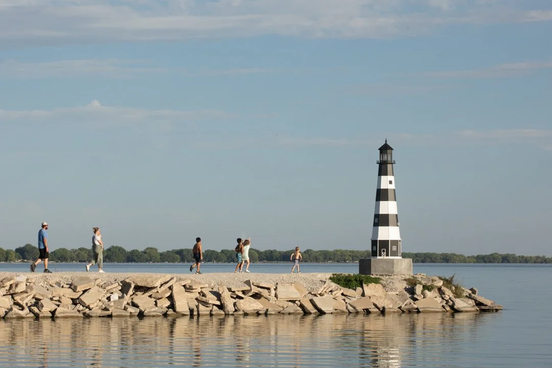landscape image of family walking out towards a lighthouse, shot by commercial photographer Corey Rourke

