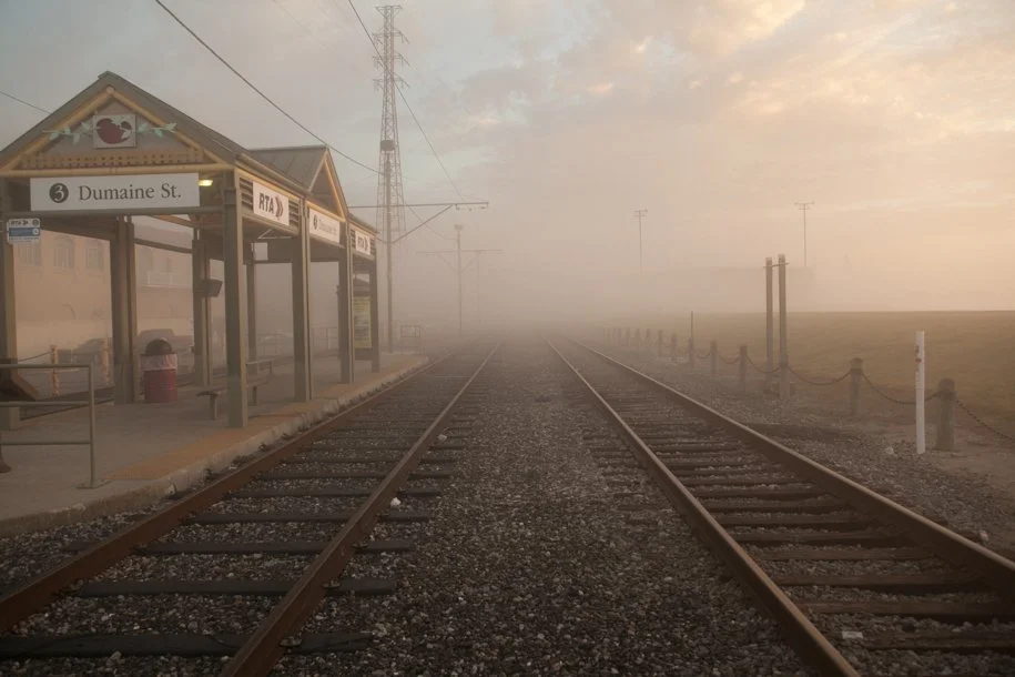 looking down two train tracks in the foggy morning
