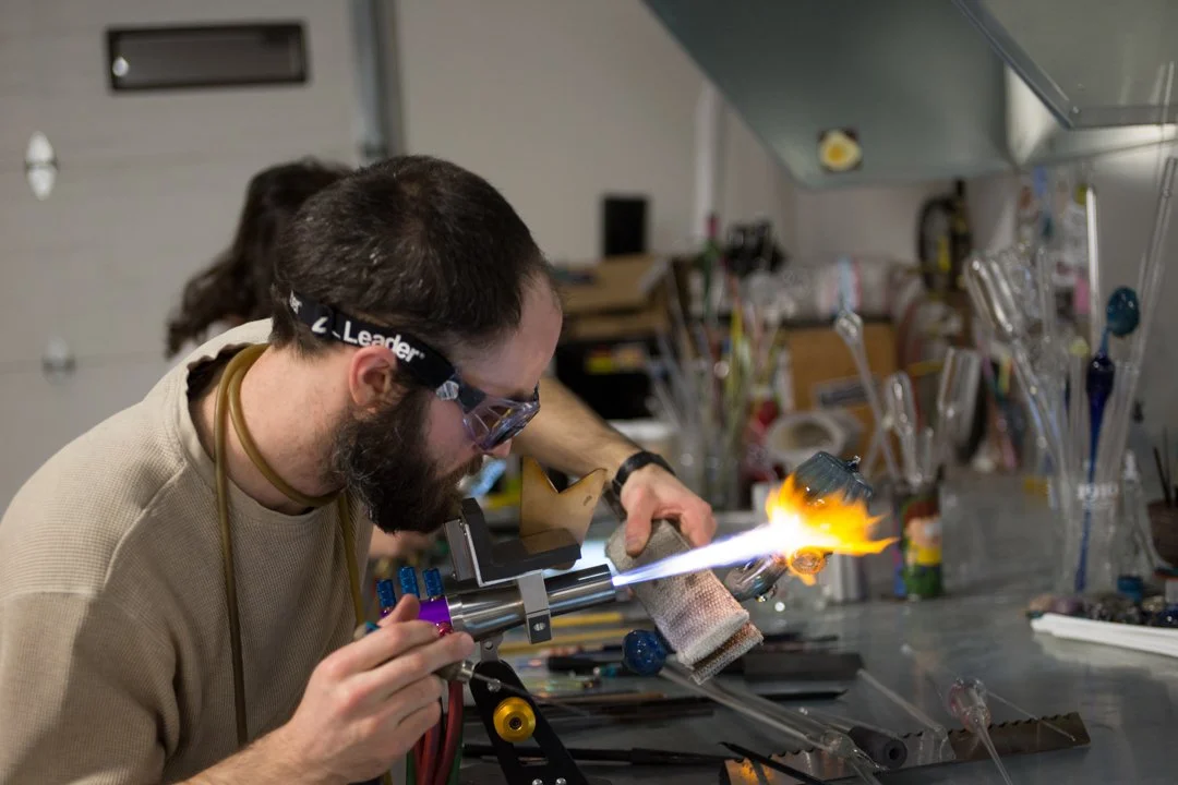 glass blower using flame to shape pipe, shot by commercial photographer Corey Rourke

