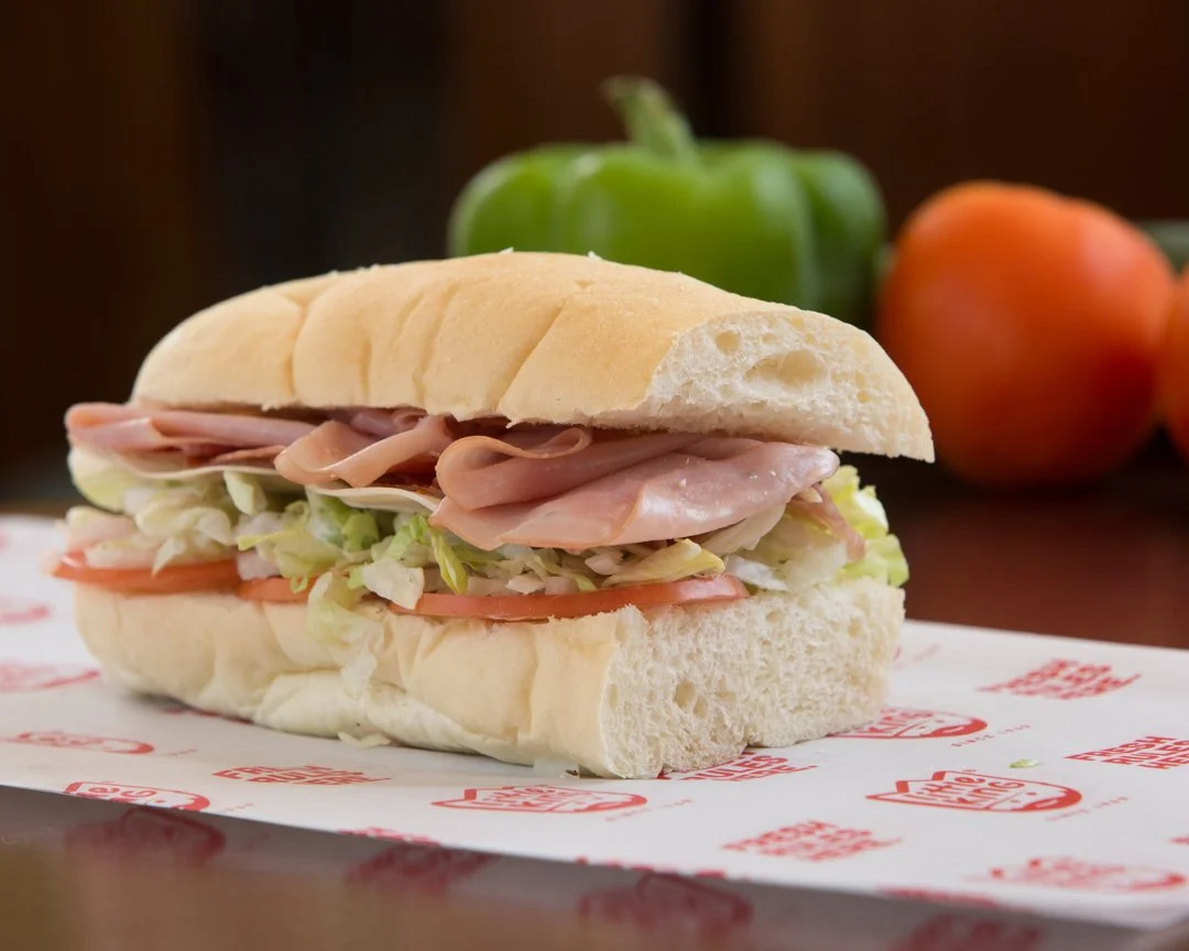 sub sandwich on paper with green pepper and tomato in background, shot by commercial photographer Corey Rourke


