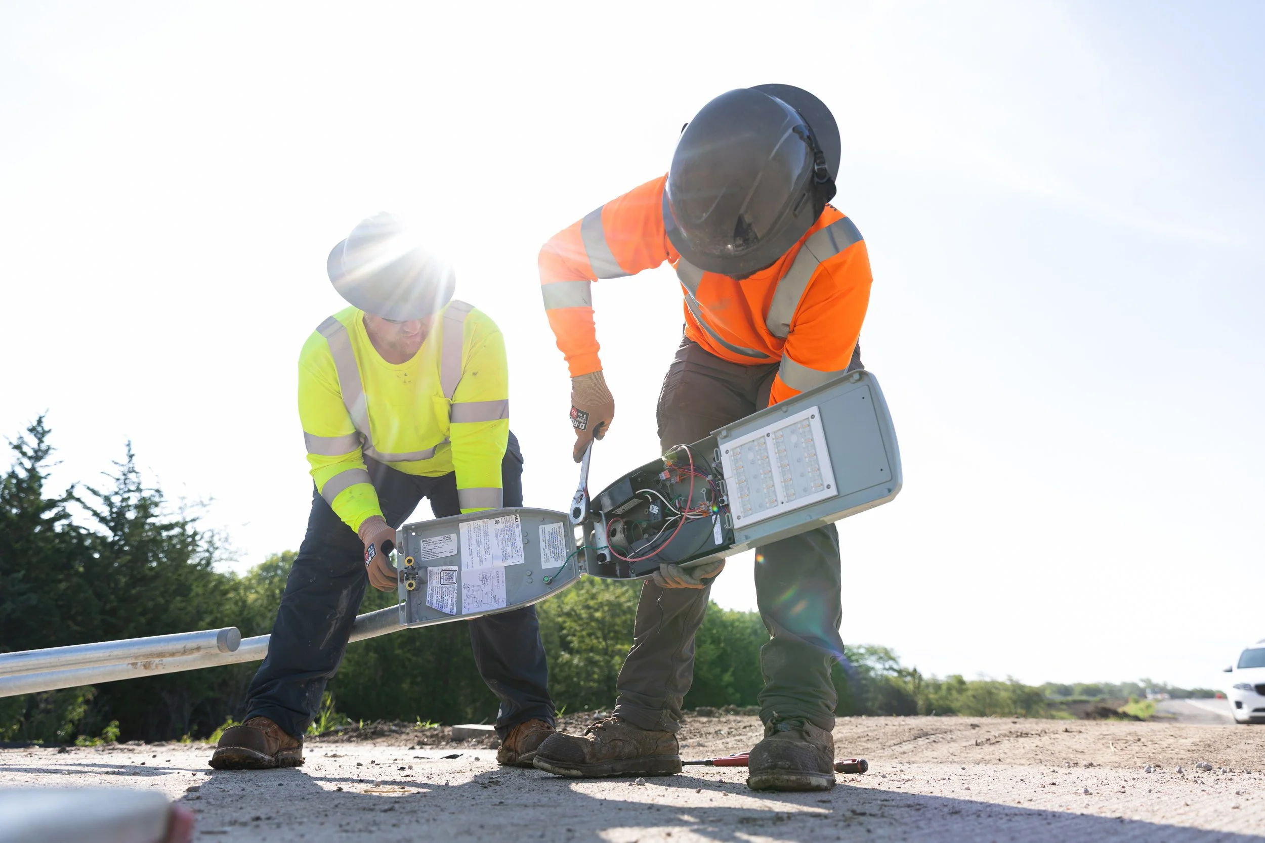 Construction workers installing a lamp on light poles, shot by commercial photographer Corey Rourke