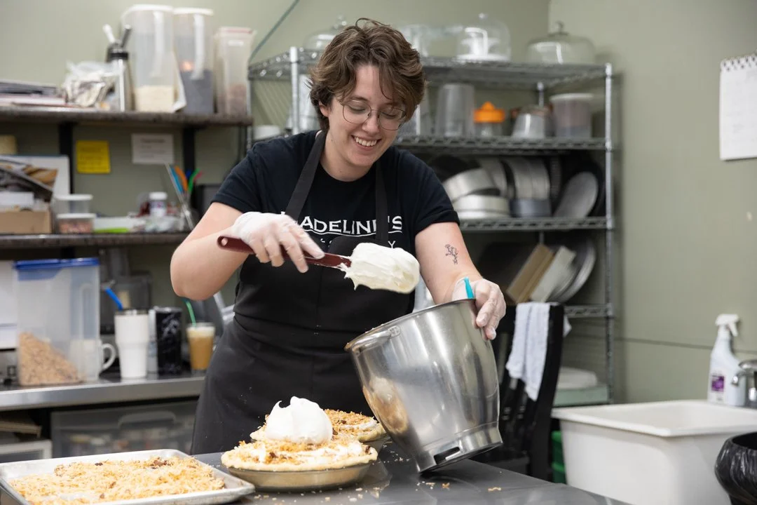 female cook placing whip cream from bowl onto a pie, shot by commercial photographer Corey Rourke

