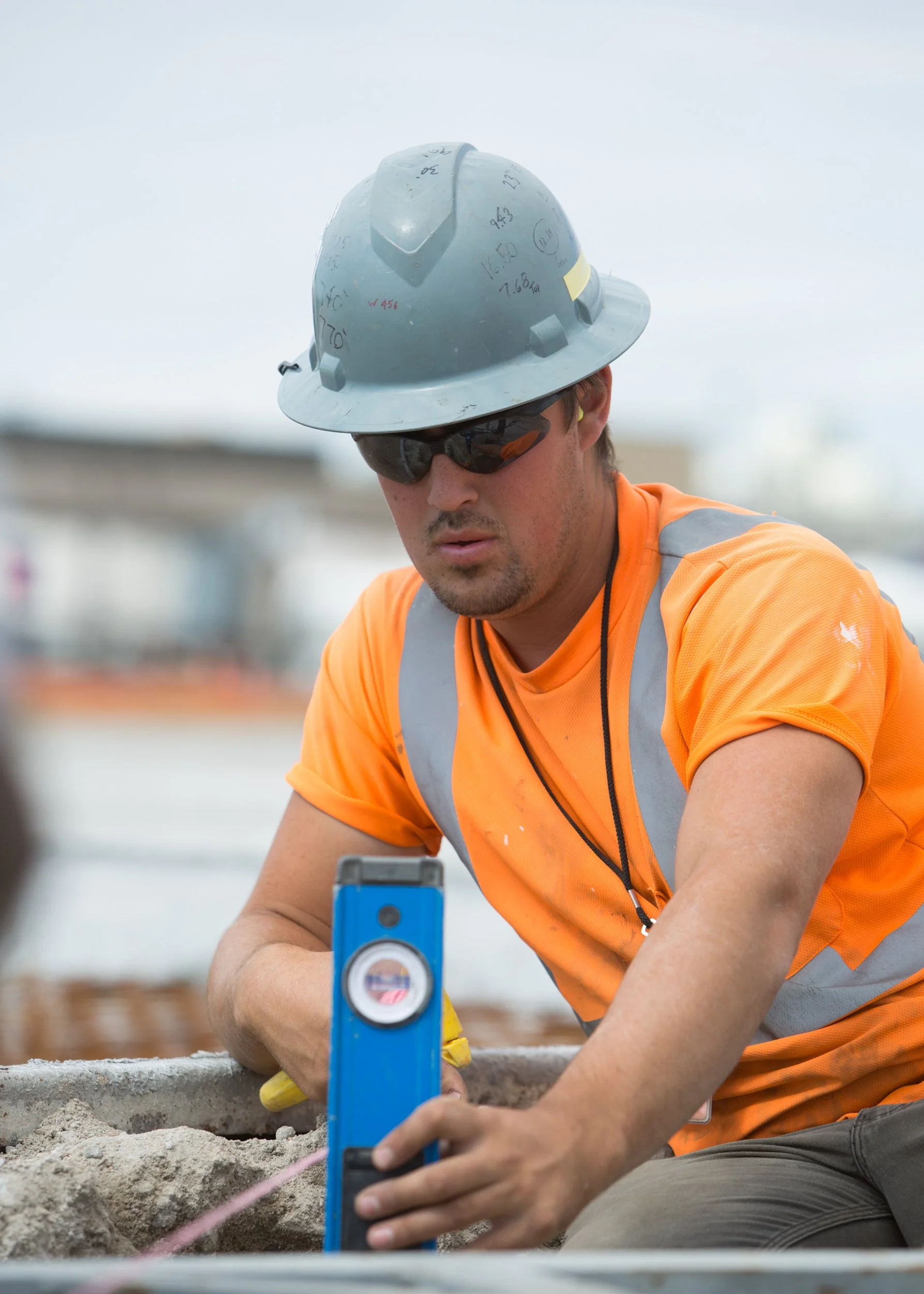 construction work checking the level of string at the job site, shot by commercial photographer Corey Rourke

