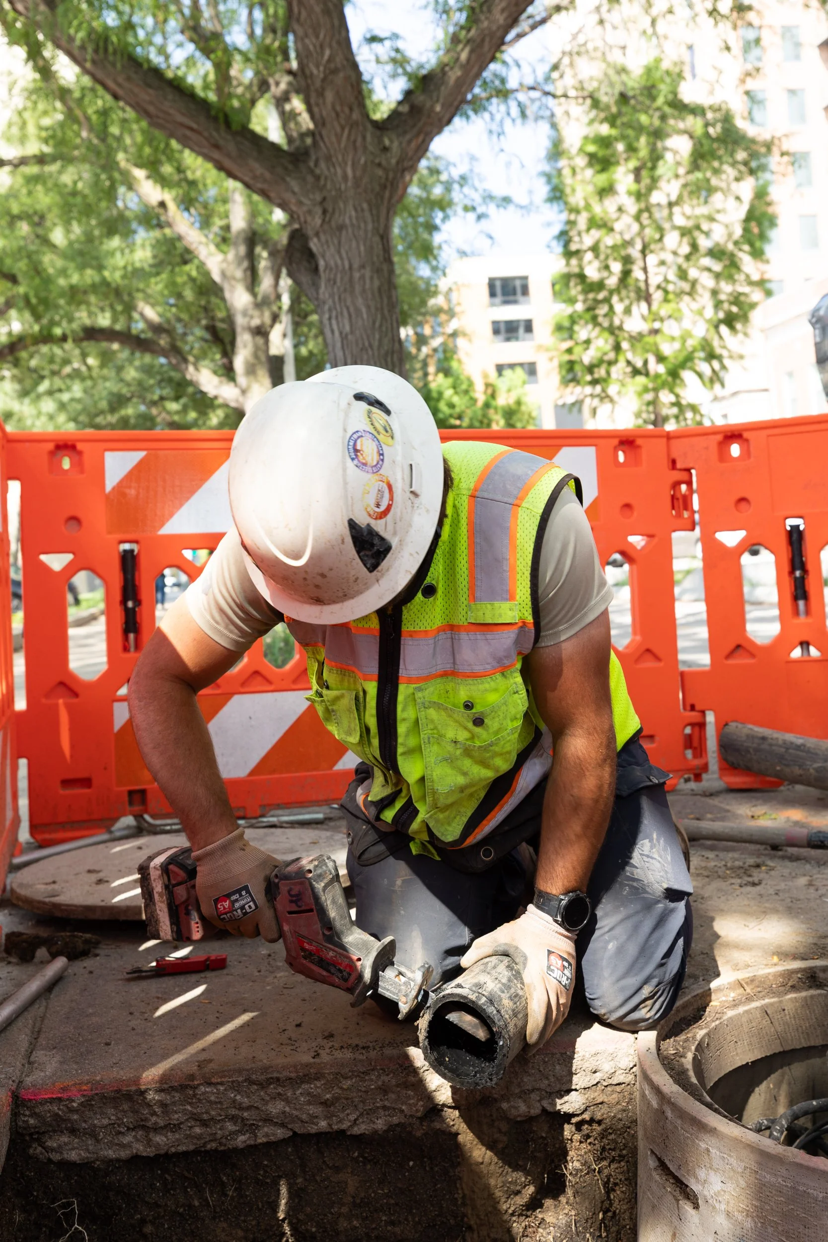 Construction worker cutting plastic tubing shot by commercial photographer Corey Rourke