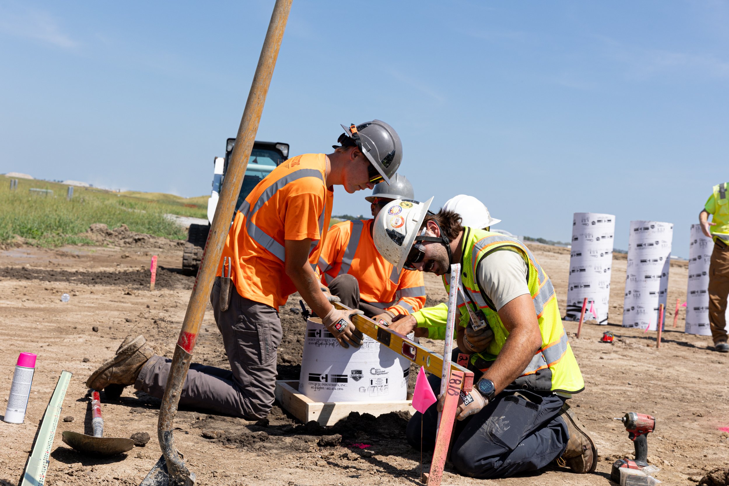 Construction workers using a level to measure an industrial installation.  Shot by commercial photographer Corey Rourke
