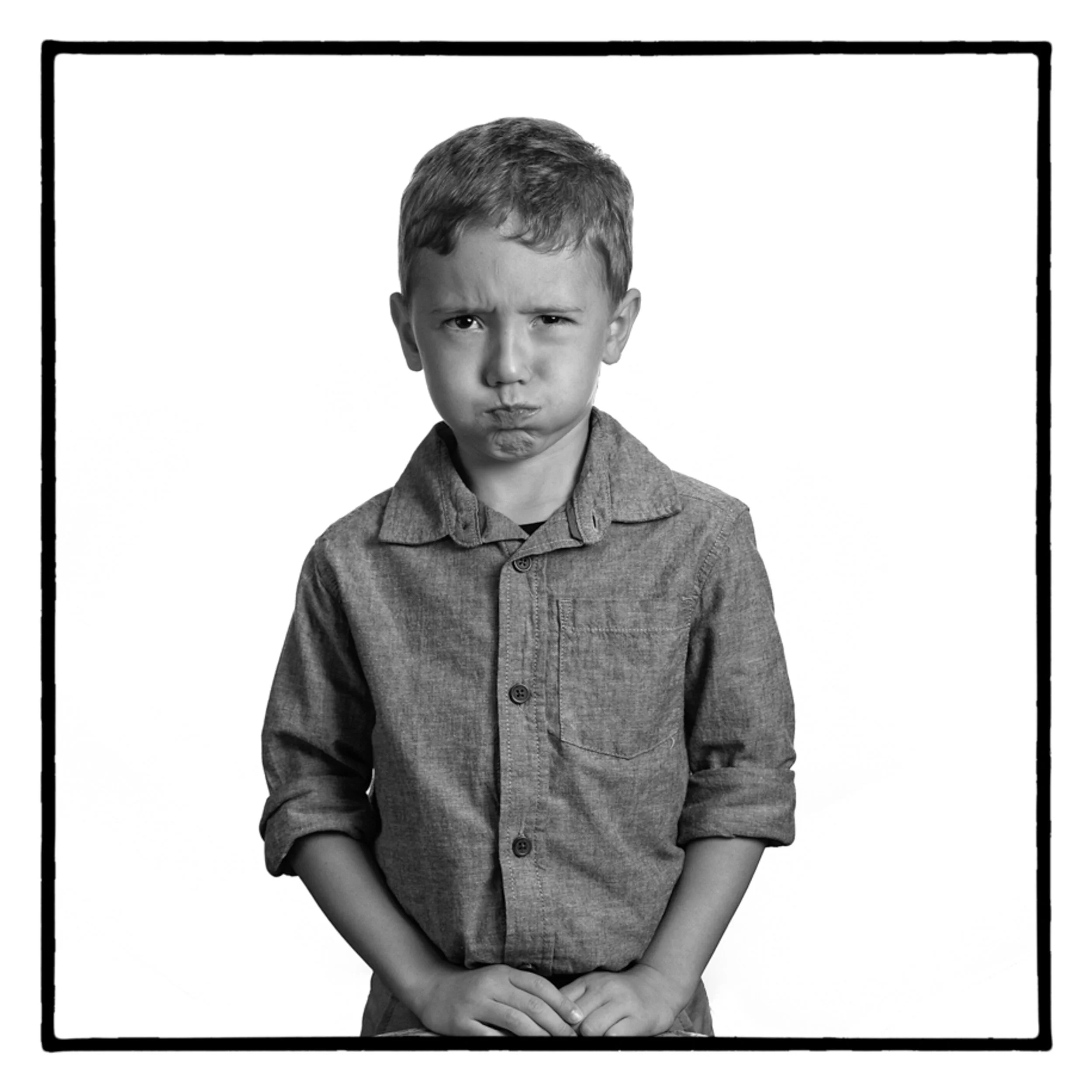 black and white portrait of young boy holding his breath, shot by commercial photographer Corey Rourke

