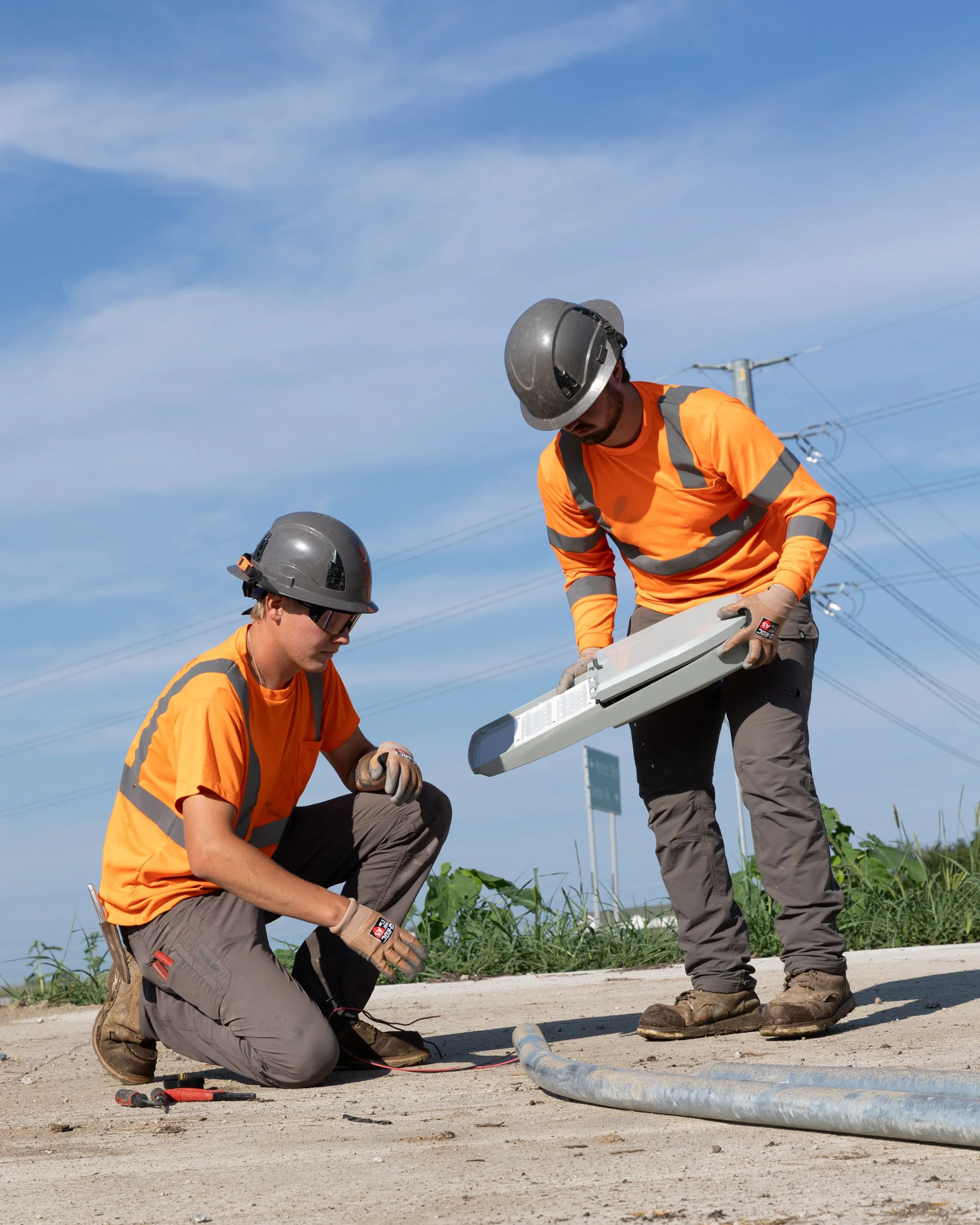 Construction workers installing a lamp on light poles, shot by commercial photographer Corey Rourke
