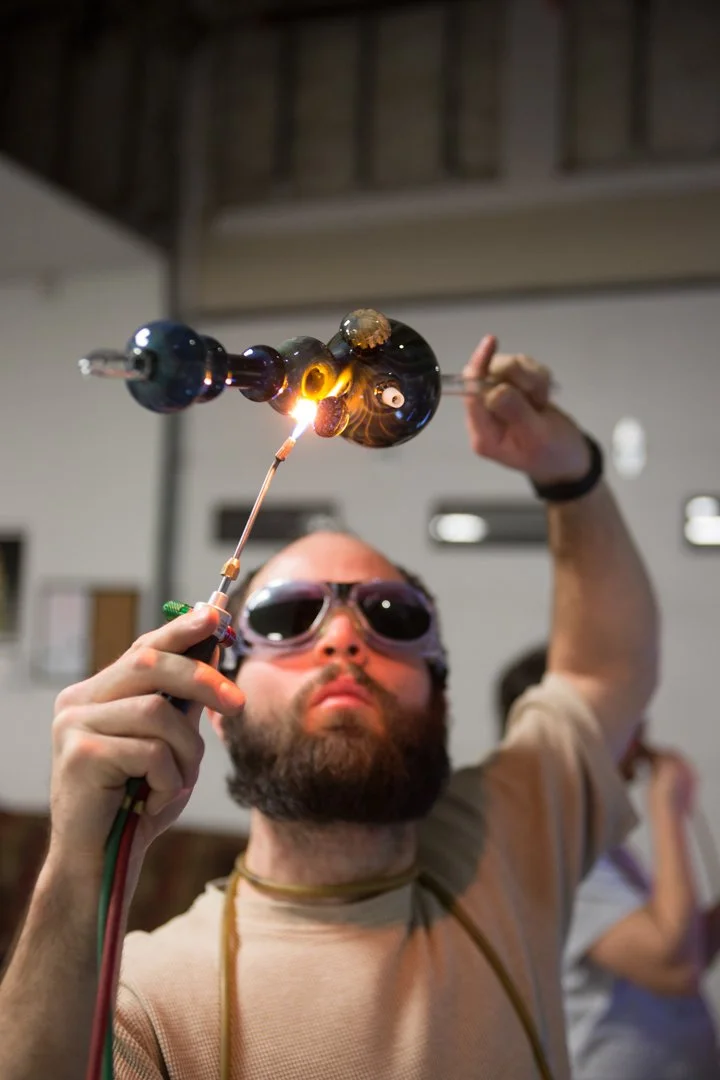 glass blower using torch to fix pipe, shot by commercial photographer Corey Rourke

