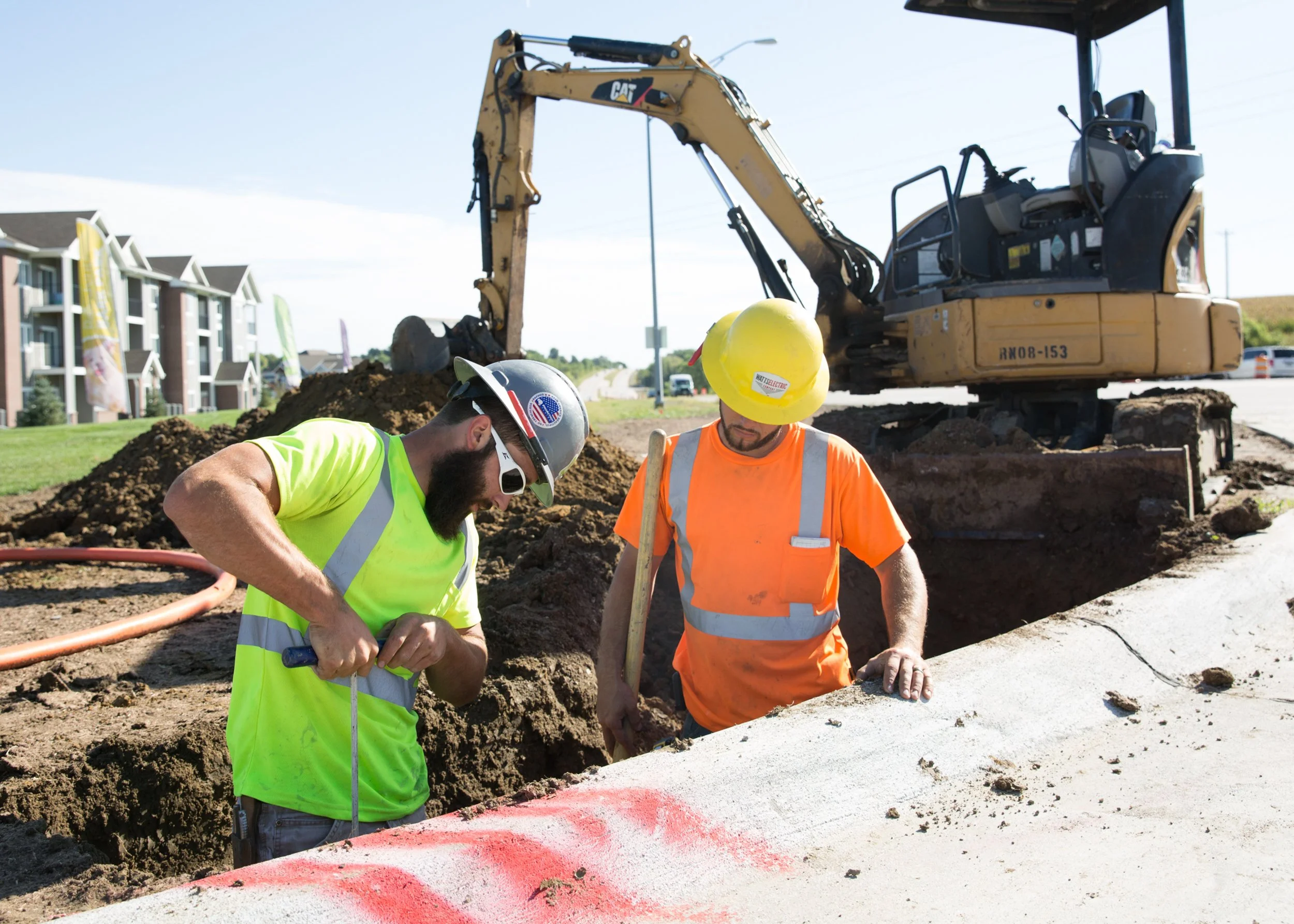 construction workers drilling a hole in trench by the curb, shot by commercial photographer Corey Rourke

