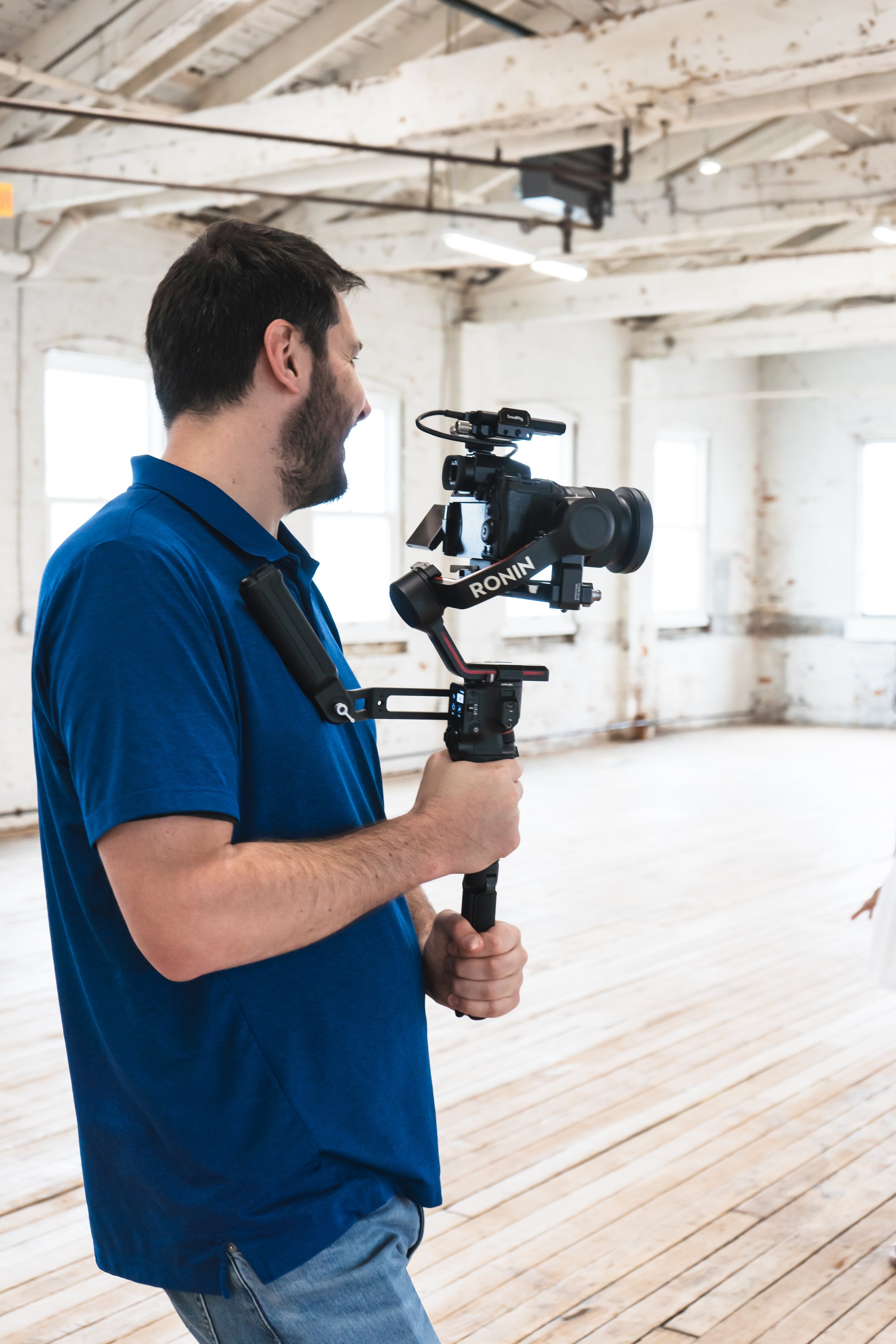 a behind the scenes shot of a videographer from Toronto Ontario Canada prompting his model in her pose.