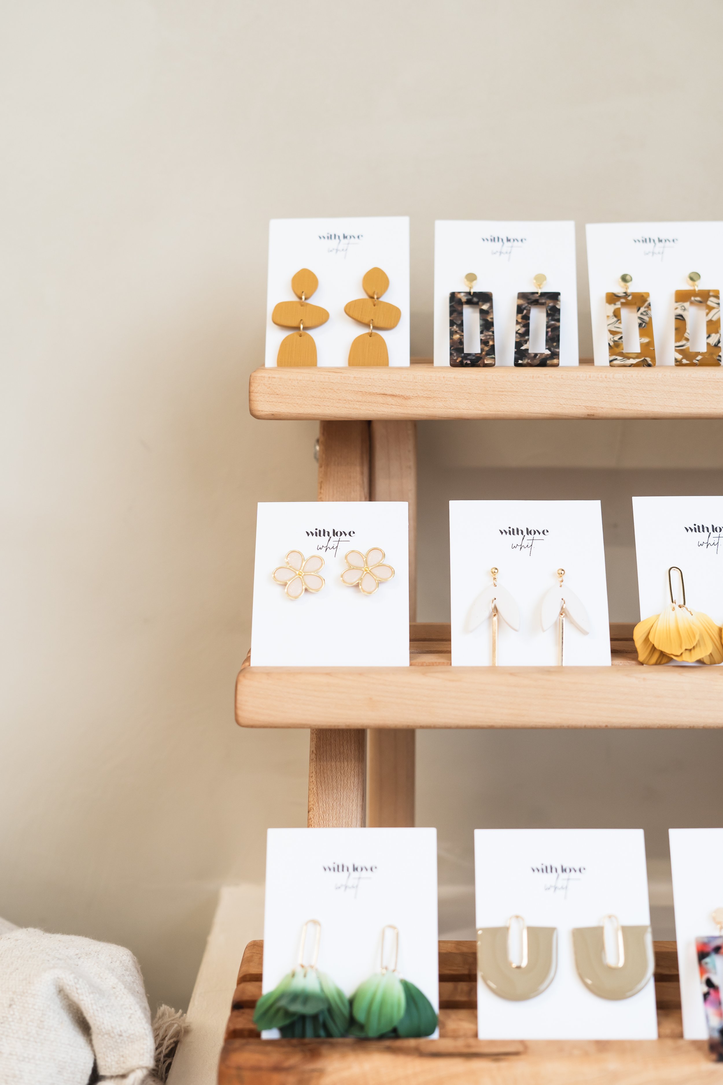Handmade earrings from Cambridge Ontario Canada displayed on a wooden shelf.