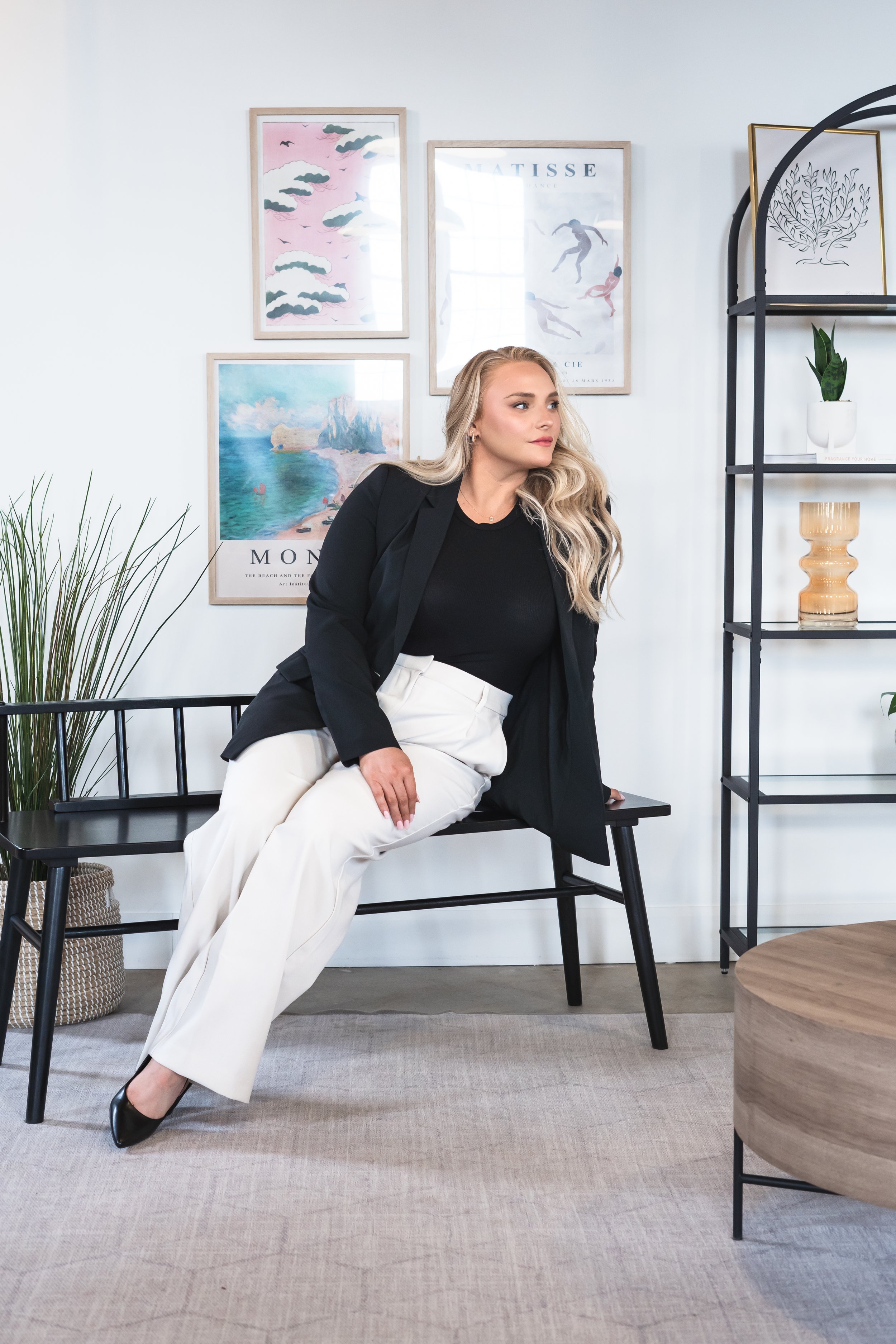 Real estate agent from Hamilton Ontario Canada posing on a black bench with modern art in the background.