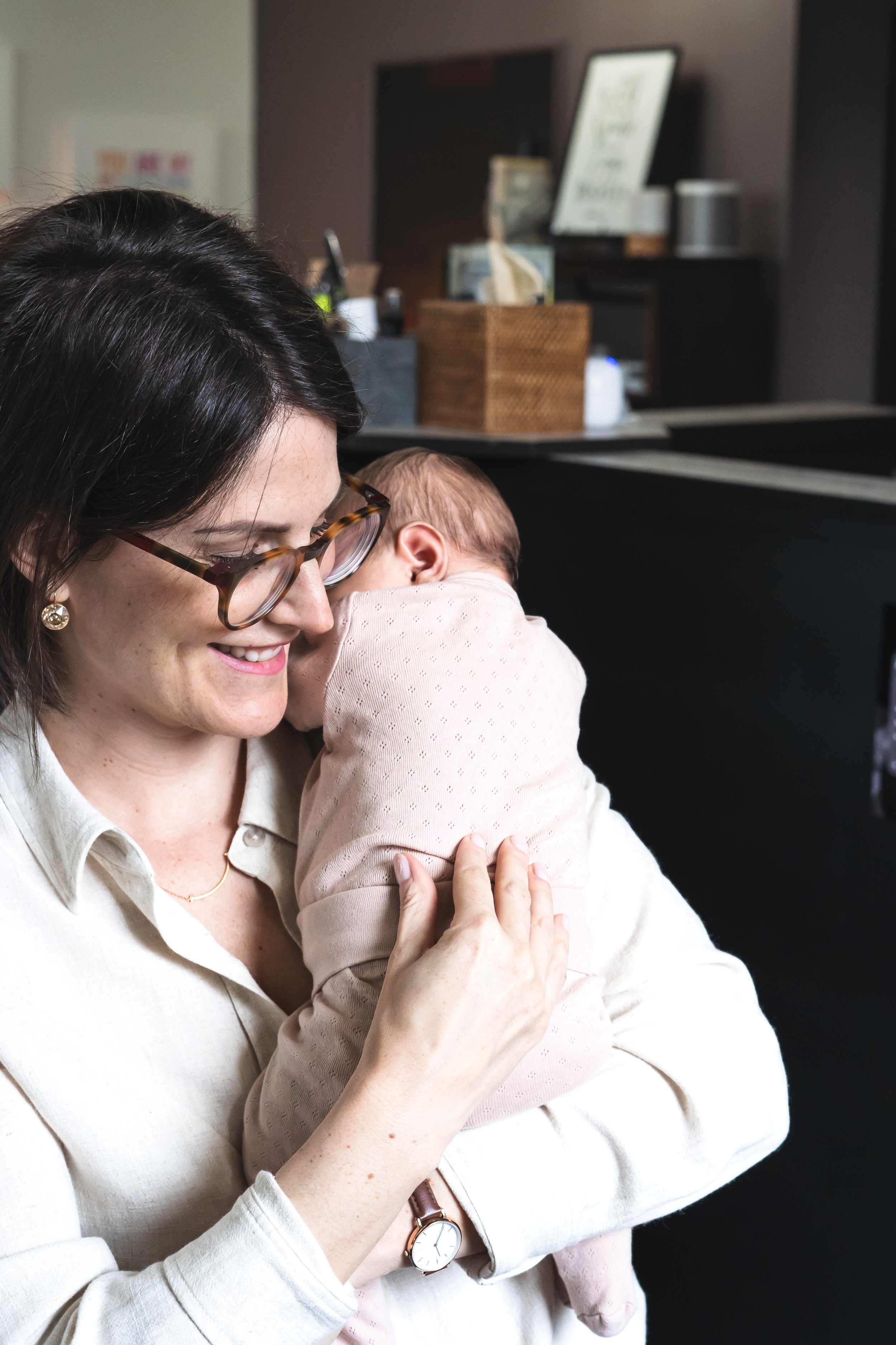 A chiropractor from Brantford Ontario Canada adjusting a baby over her shoulder.