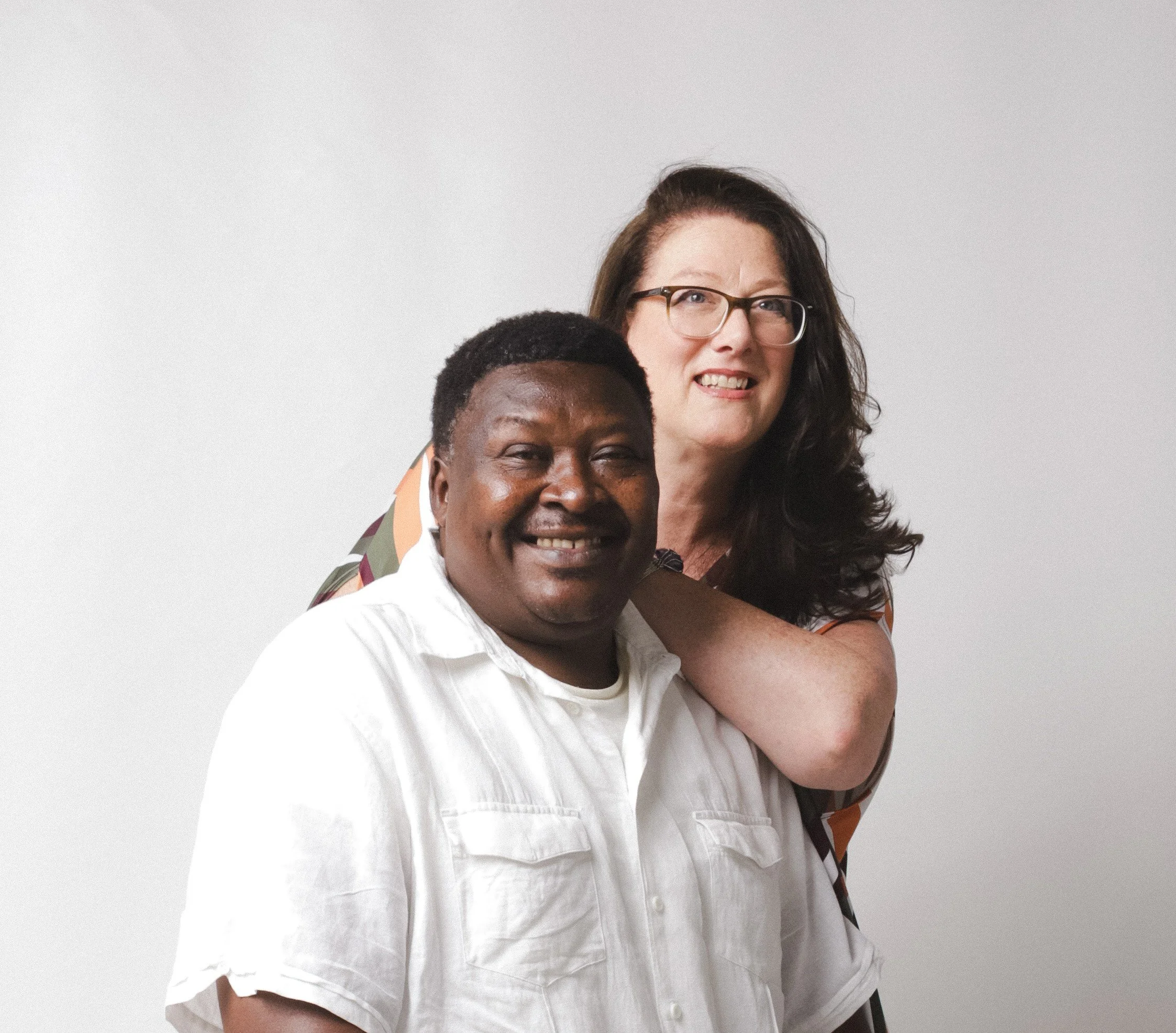 Close-up of diverse smiling people, partial view of their faces and shoulders.