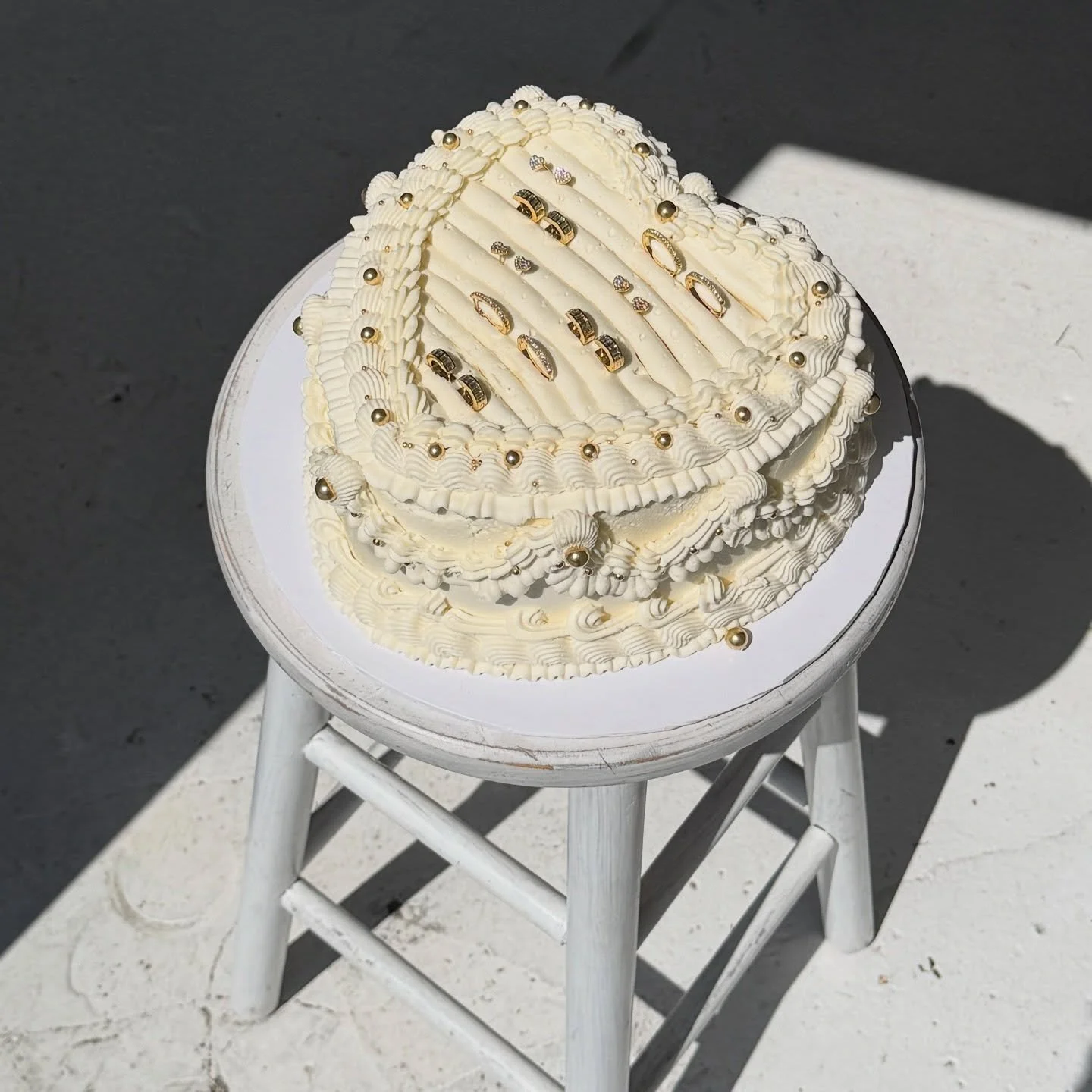 Just some simple cake toppings like 14k gold and diamond earrings idk!! 

Happy birthday to @cuffedbynano 🎉 custom heart stacked cheesecake with vintage buttercream &amp; gold bead sprinkles 🫶🏻