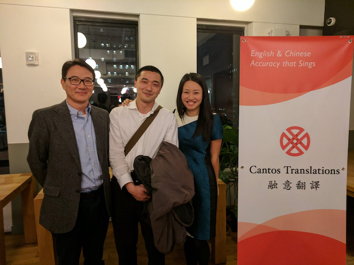 Judy Zhou standing with two people and a sign advertising Cantos Translations.