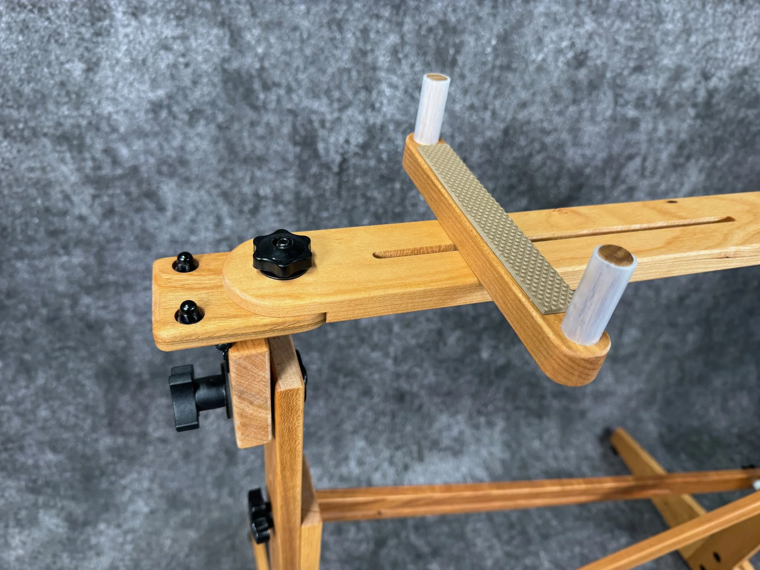 A close-up view of a mountain dulcimer stand and its swivel plate and instrument brace.